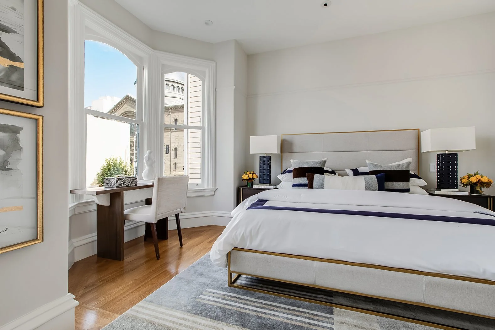 Luxury primary bedroom highlighting high-end staging, a custom built-in desk, and abundant natural light in a renovated San Francisco home.