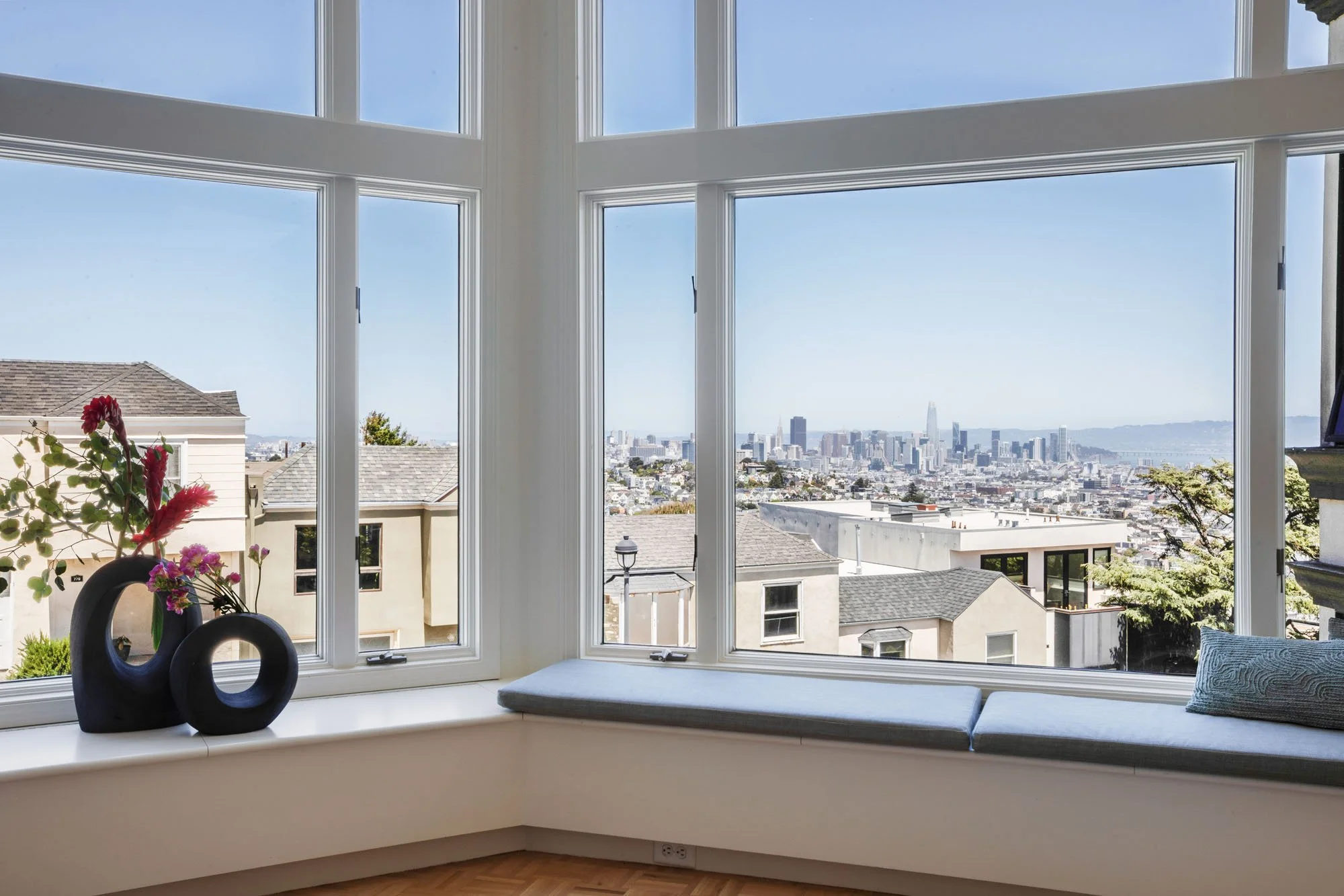 Luxury window seat in a San Francisco home offering a breathtaking panoramic view of the downtown skyline, including the Salesforce Tower and Transamerica Pyramid.