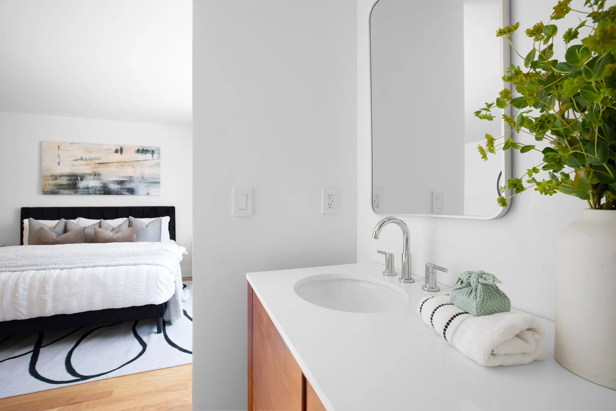 Primary en-suite vanity at 932 Broderick Street #2 with a quartz counter and chrome fixtures, opening directly to the bedroom with its dual-vanity layout.