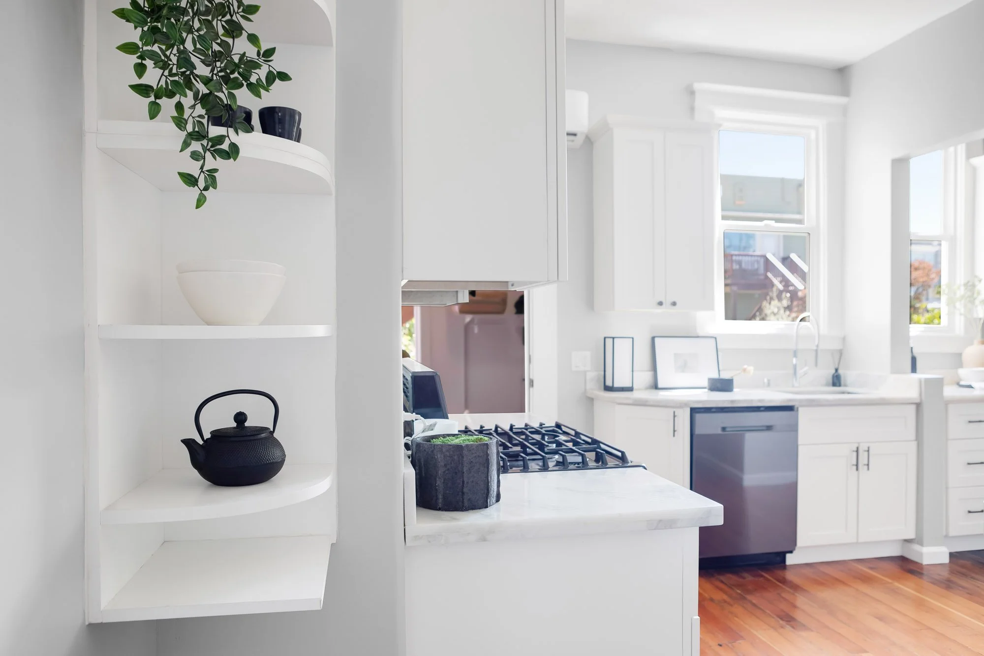 Kitchen gas range and pass-through window opening to the dining nook