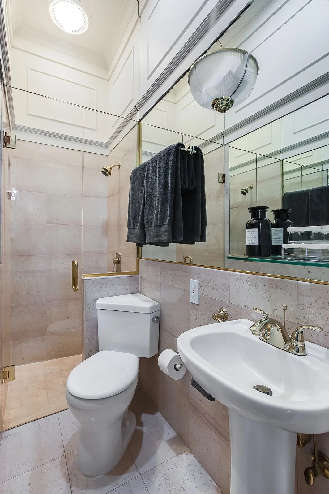 Elegant secondary bathroom with vintage-inspired gold fixtures, a pedestal sink, and classic tilework in a historic Victorian home.