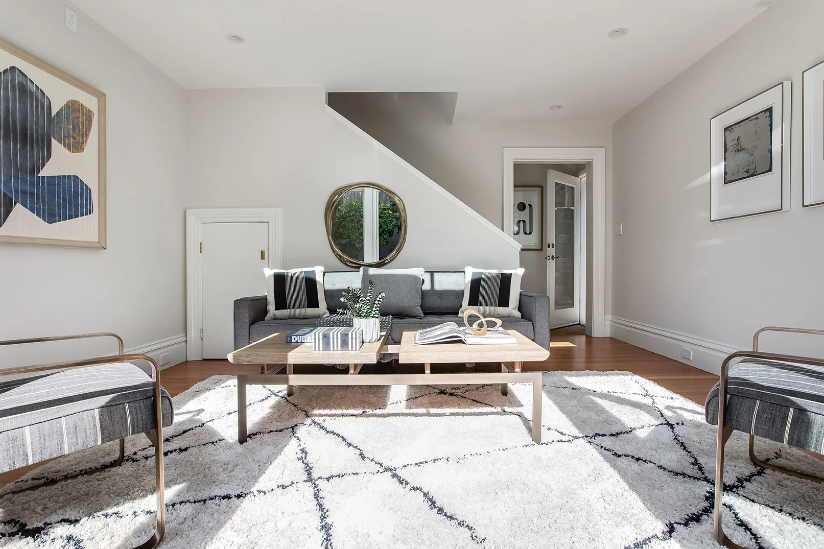 Bright, open-concept family lounge in a Pacific Heights home, featuring a modern grey sofa and designer interior finishes.