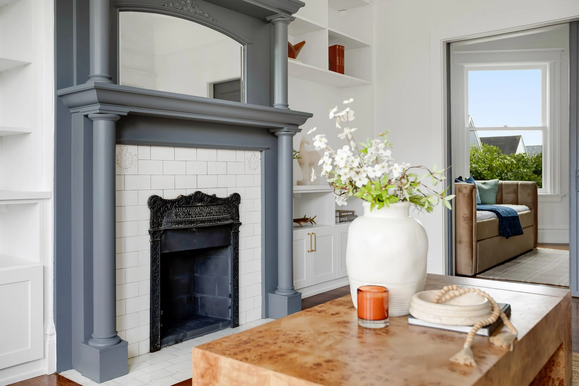 Victorian living room with ornate painted fireplace mantel, hardwood floors, crown molding, and open sight line through original doorway to hallway and bedrooms, Presidio Heights flat, San Francisco