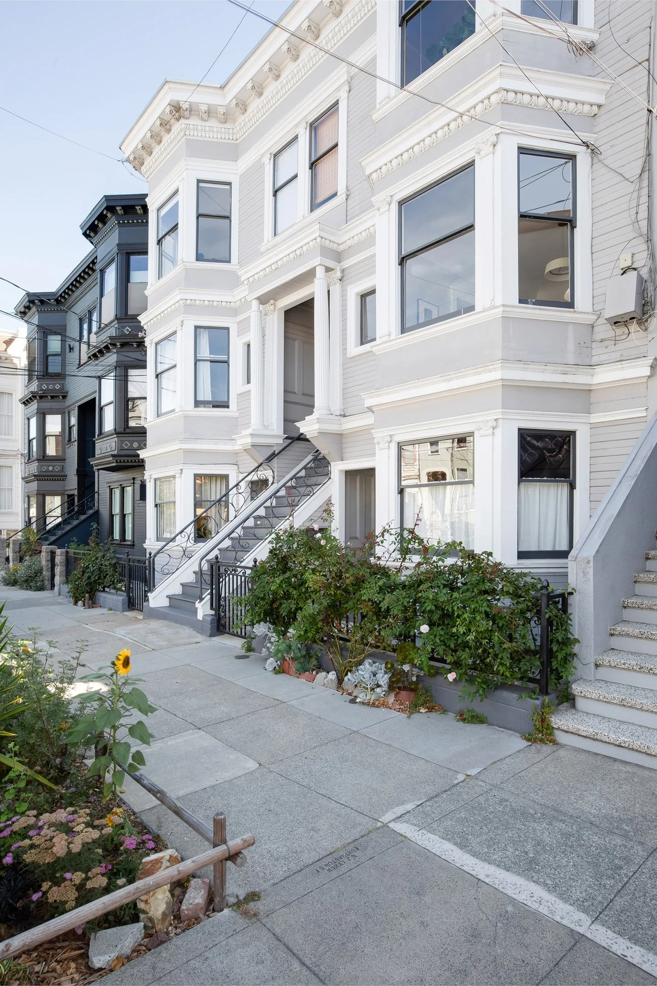 Edwardian building exterior with sidewalk garden plantings in the foreground