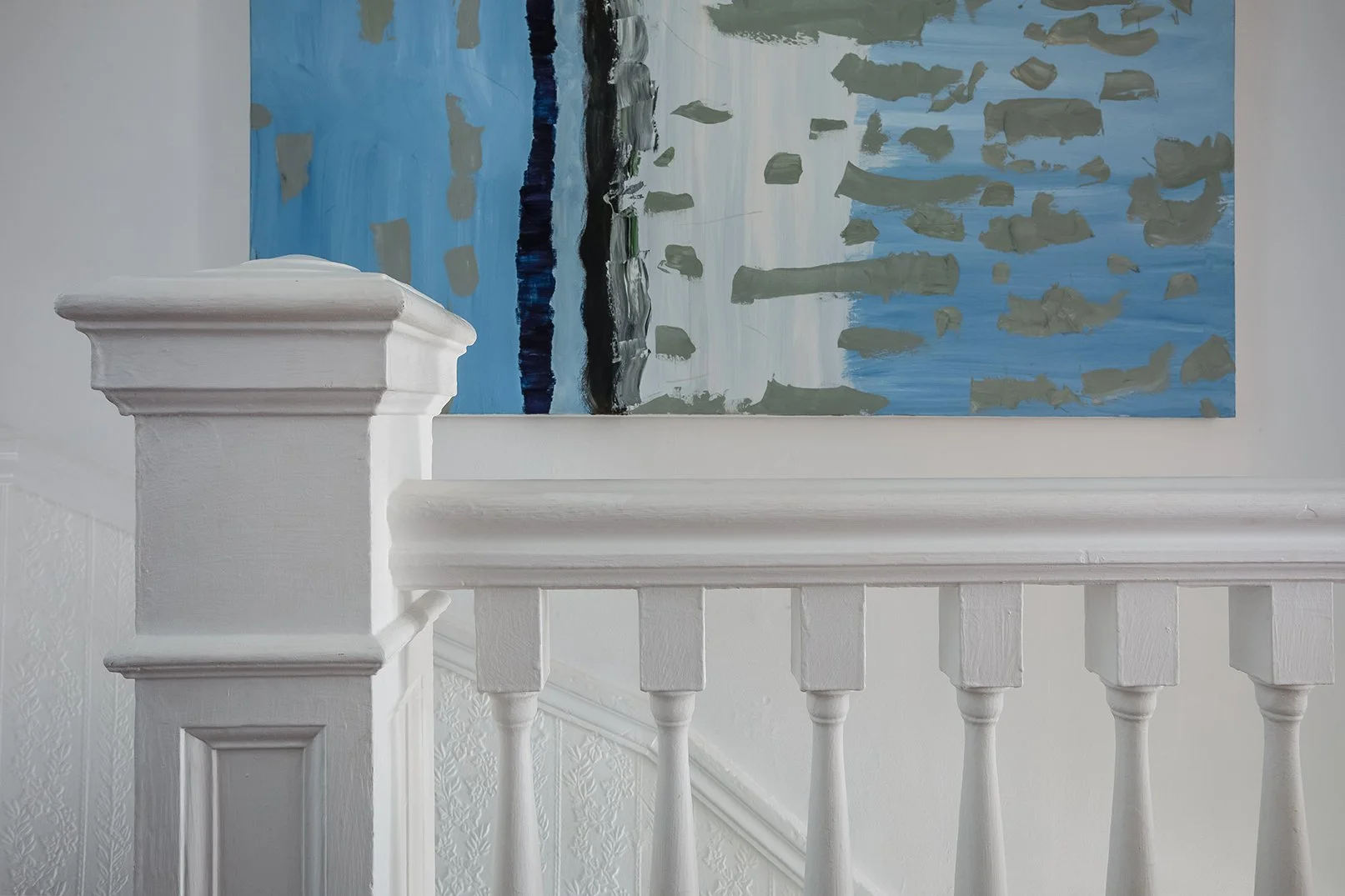 Original Victorian staircase with turned spindle balustrade, carved newel post, and embossed wall paneling in Presidio Heights Victorian flat on Sacramento Street, San Francisco