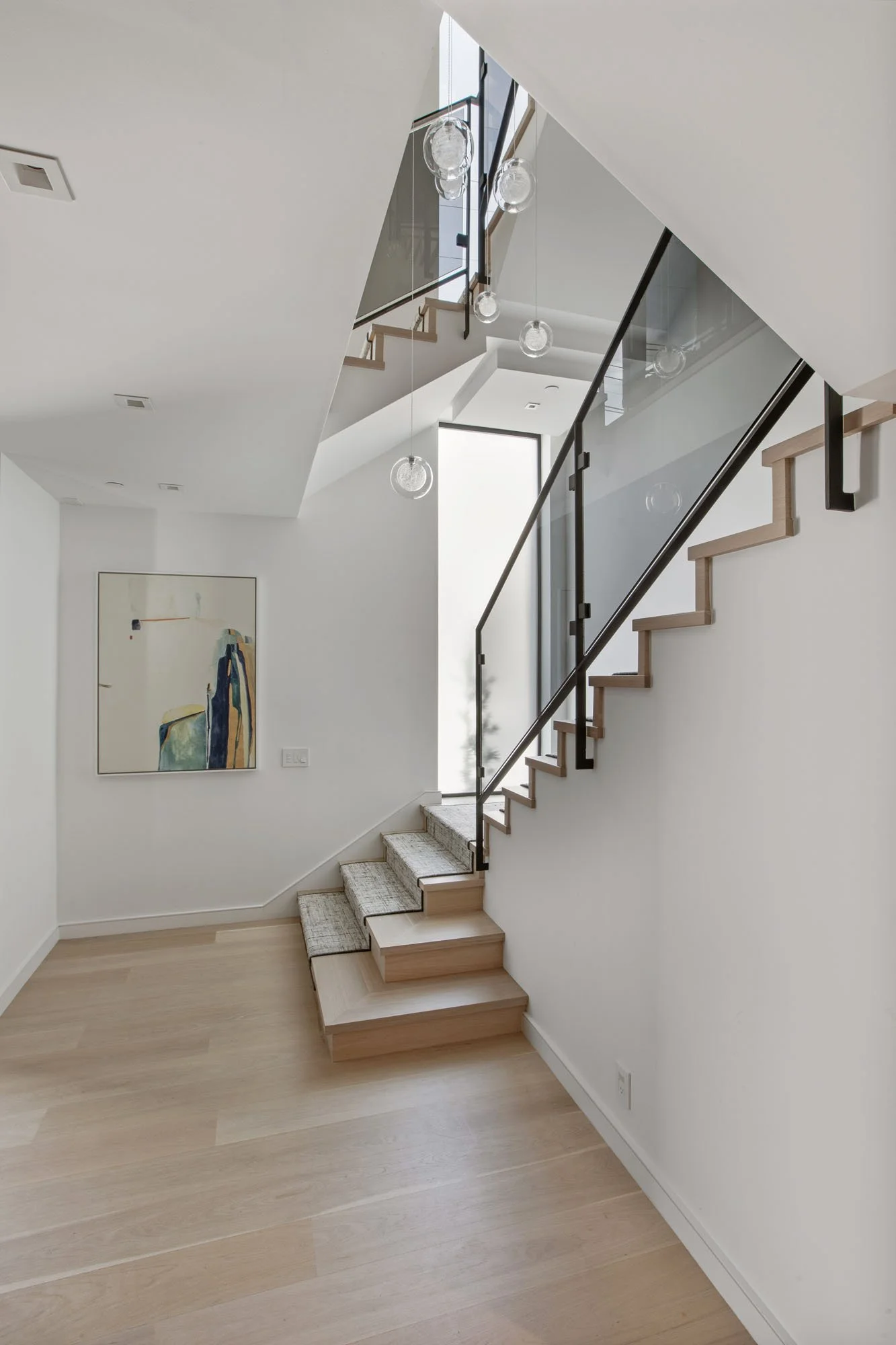 Multi-level architectural landing at 1647 Sanchez with cascading globe pendant lights and an airy, open-concept floor plan.