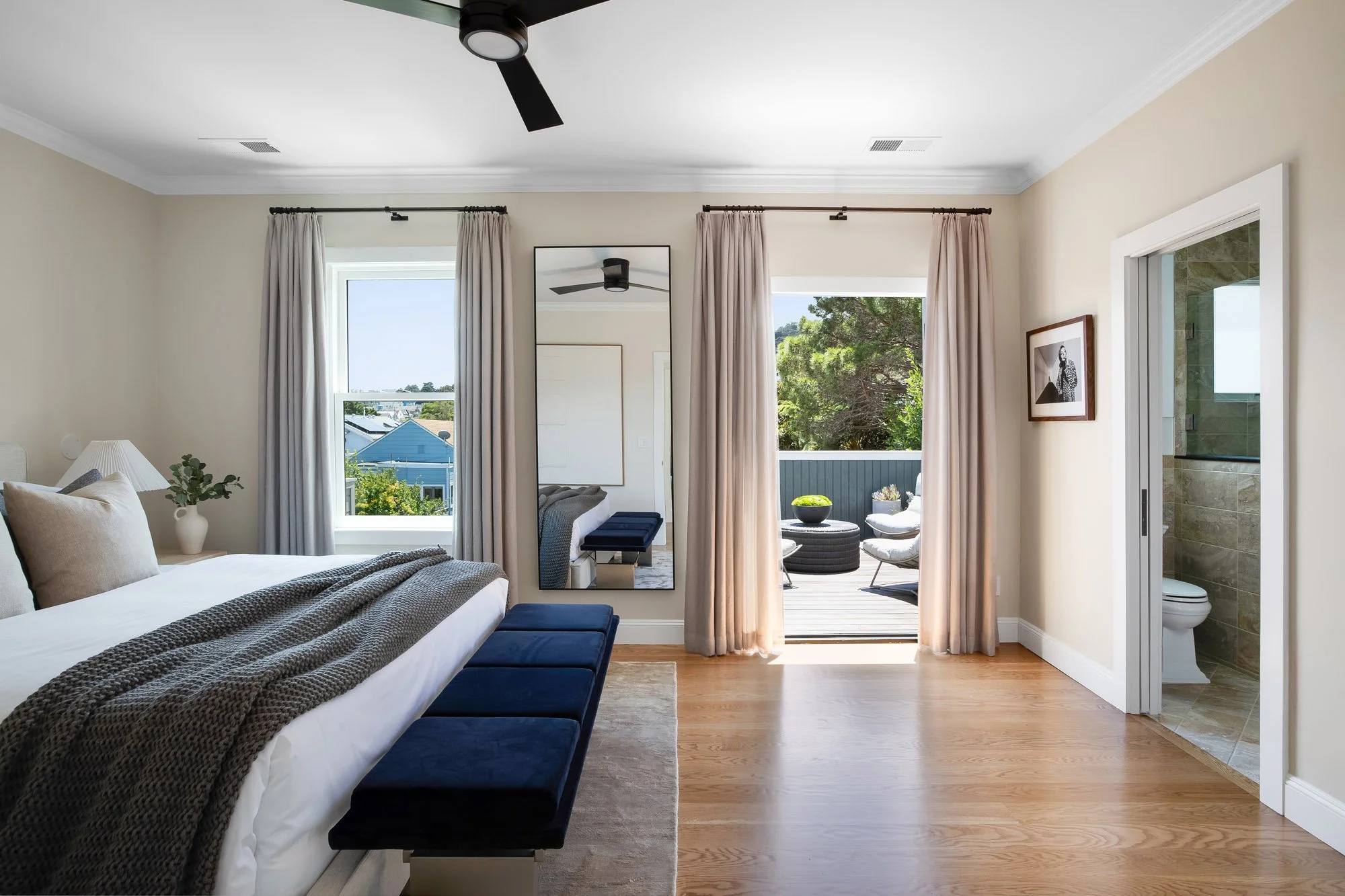 Primary bedroom at 771 Elizabeth Street in Noe Valley with treetop and neighborhood views, an en-suite bath, and French doors opening to a private deck with seating.