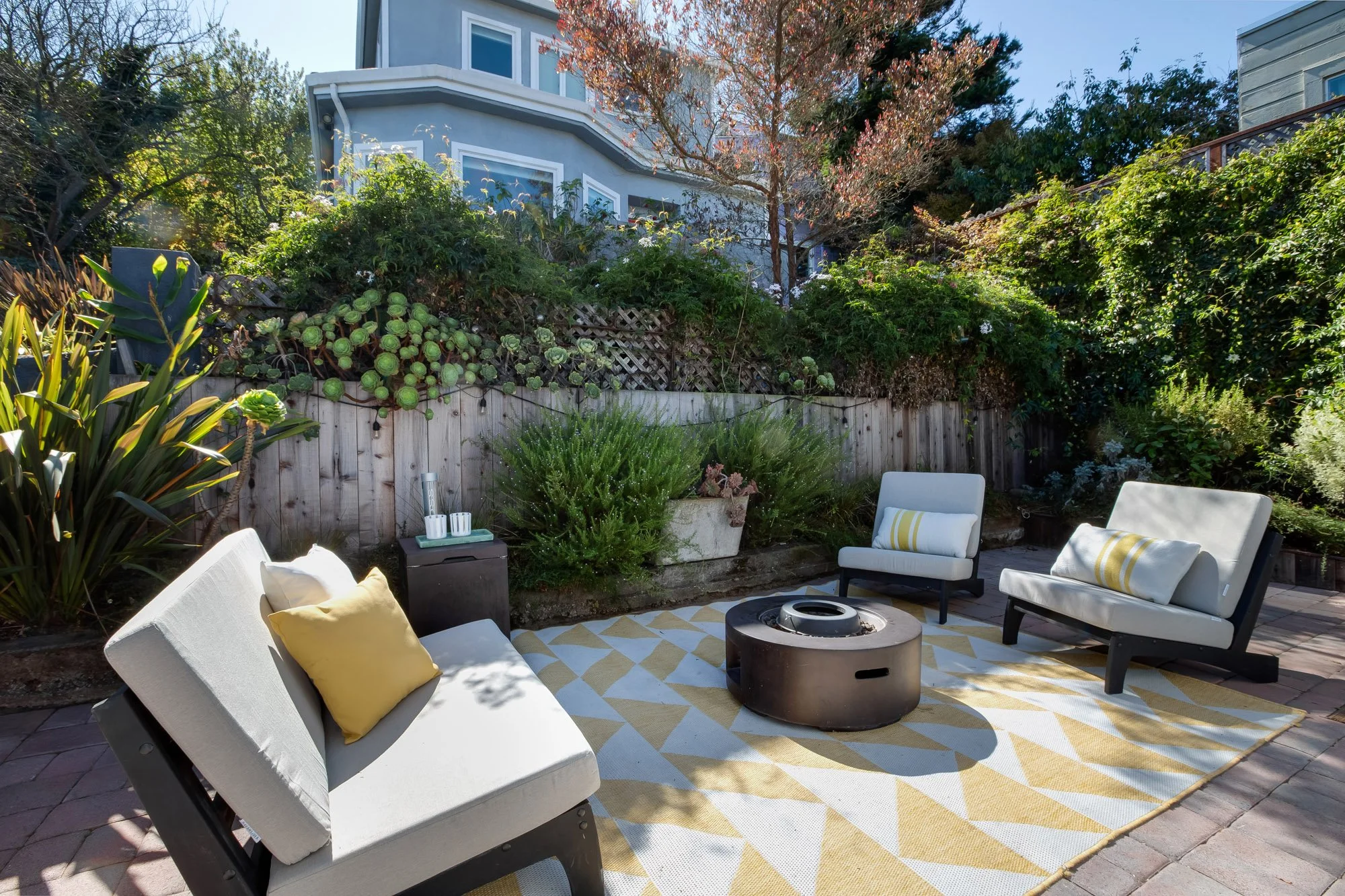 Pavered patio in an Upper Noe Valley garden, surrounded by terraced beds of succulents, rosemary and drought-tolerant plantings