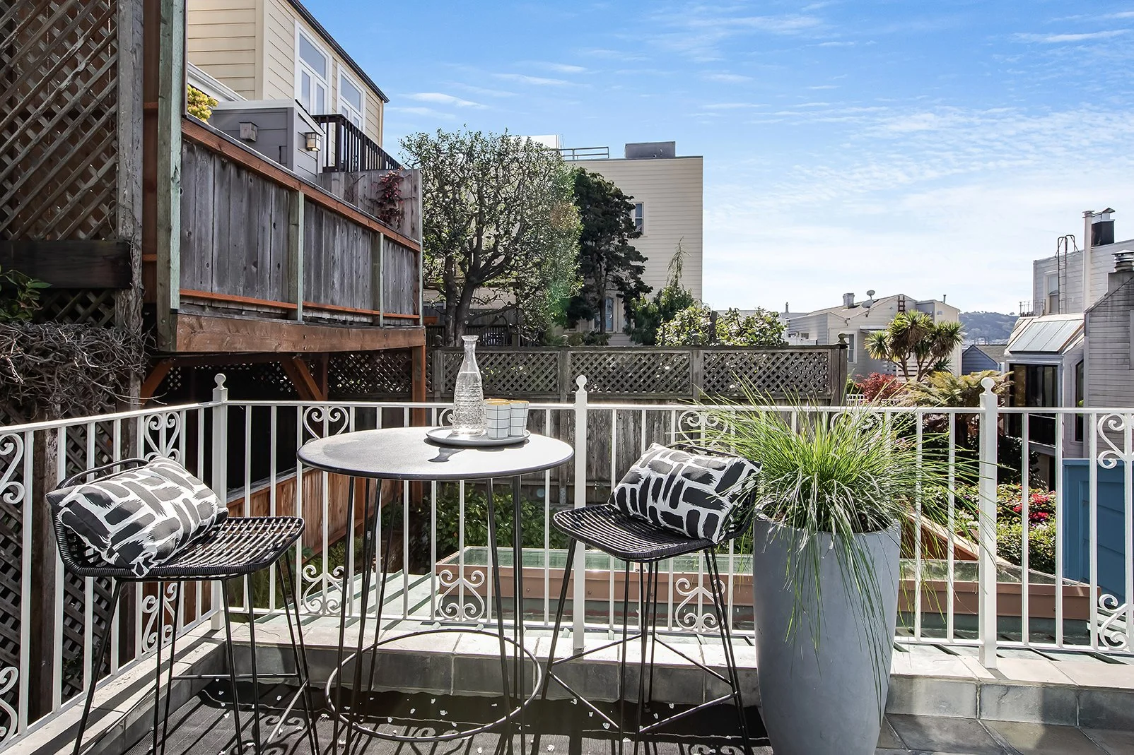 Private upper-level balcony with modern bistro seating and expansive views of the surrounding San Francisco neighborhood.