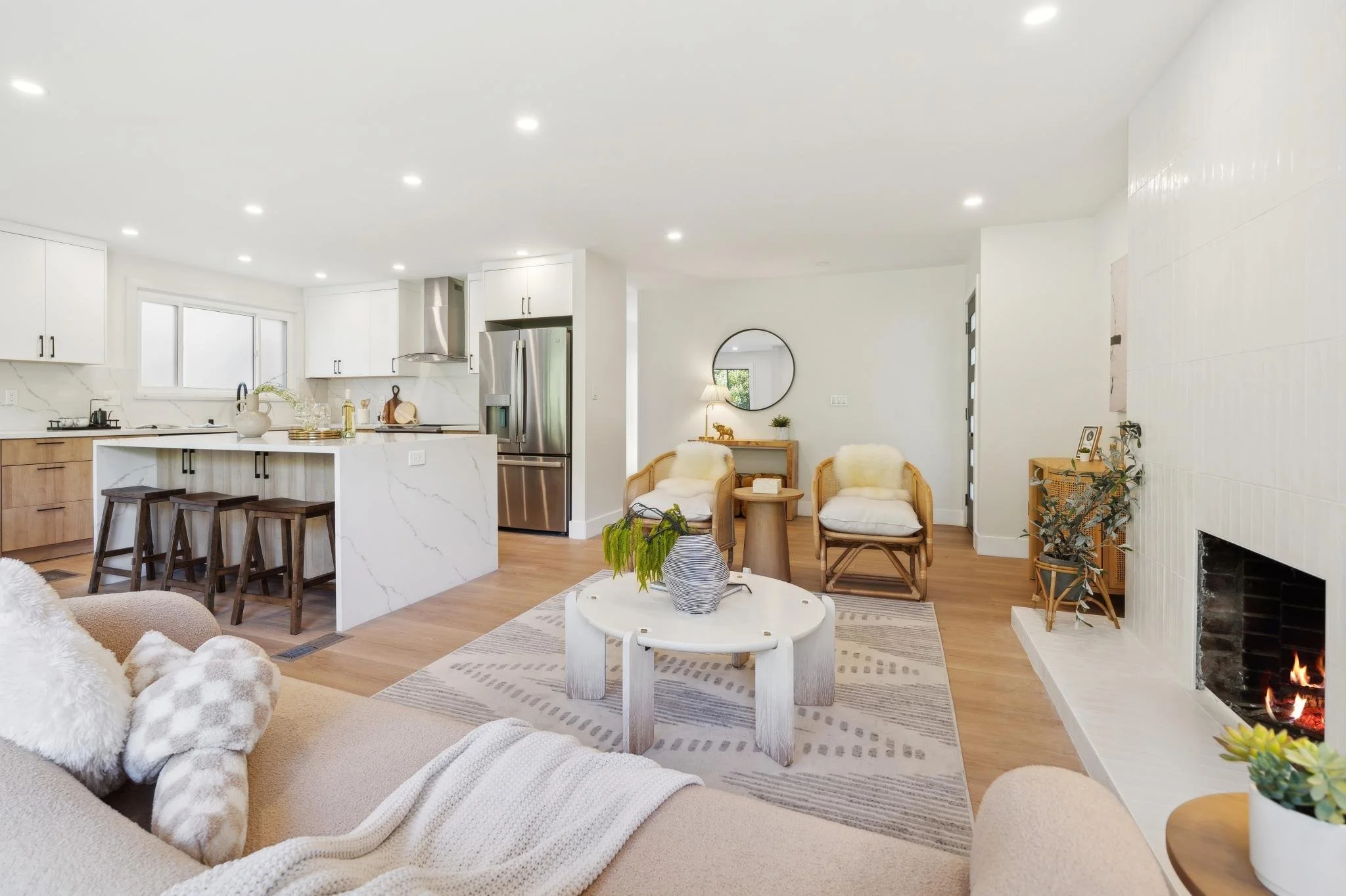 Open-concept main level showing the seamless transition from a minimalist living area to a luxury kitchen with a white marble waterfall island.