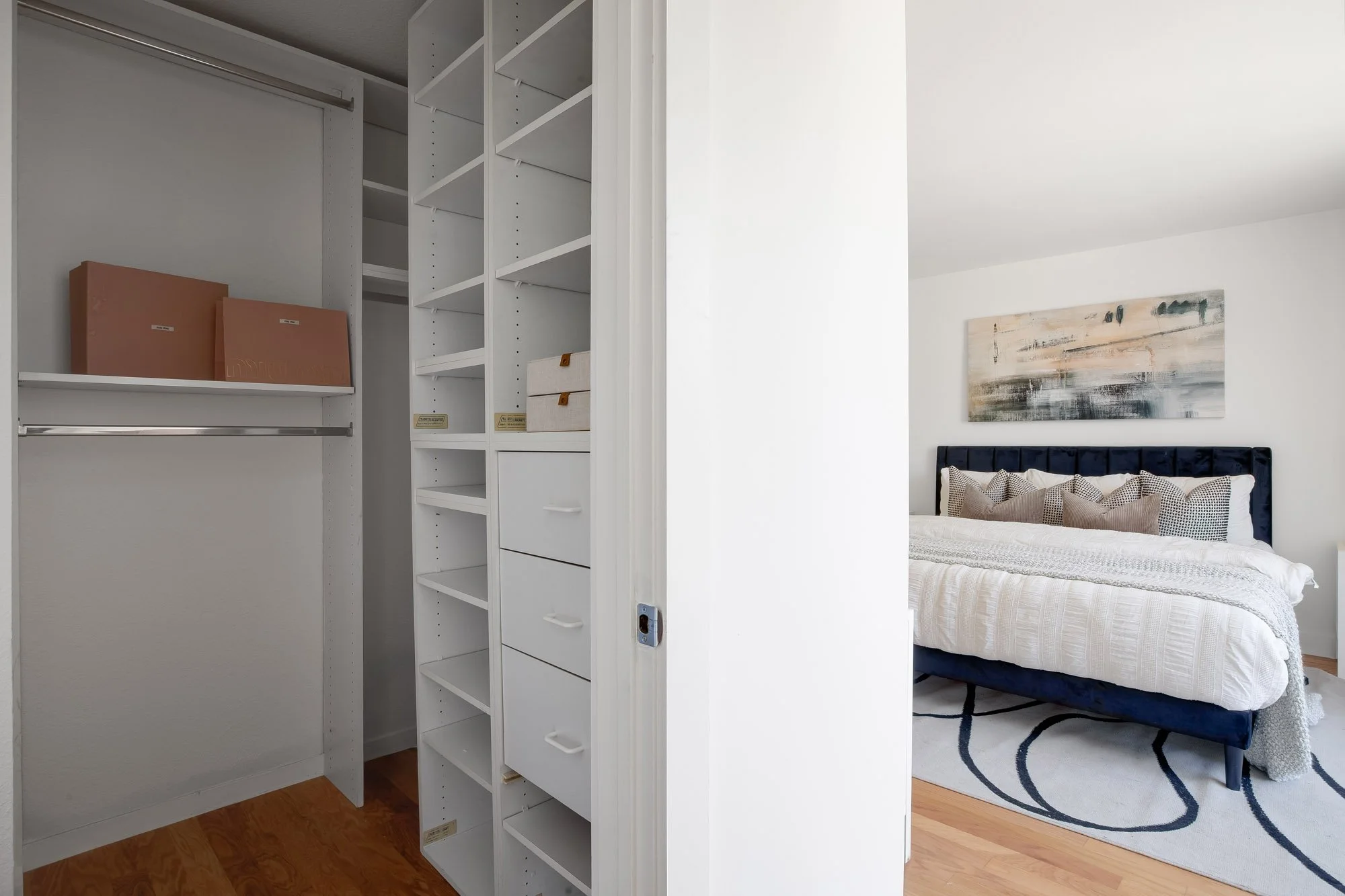 Walk-in closet at 932 Broderick Street #2 with built-in shelving, drawers, and hanging rods, adjacent to the primary bedroom in NoPa, San Francisco.