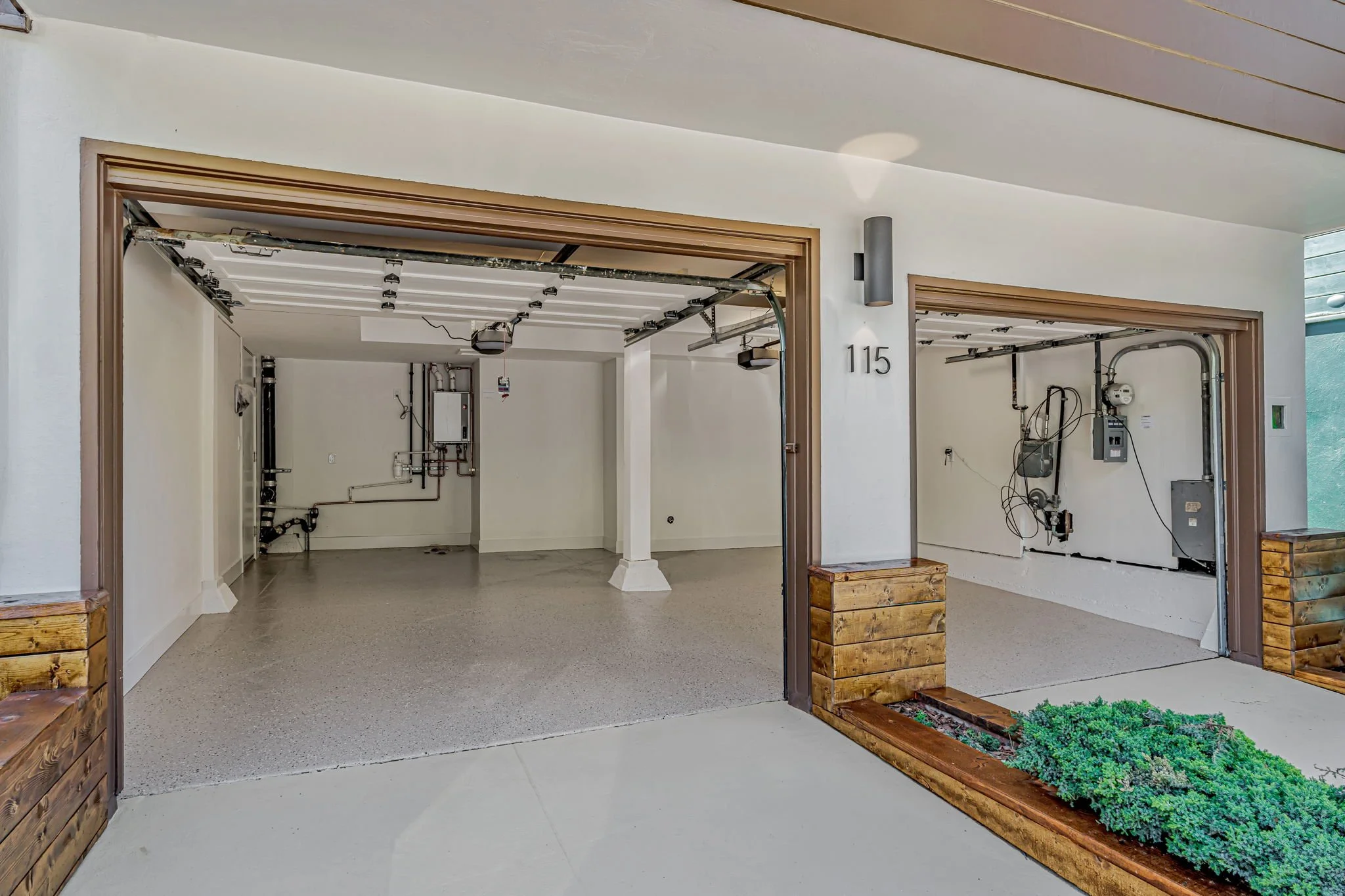Interior view of a spacious two-car garage in San Francisco with gray epoxy floors, clean white walls, and upgraded utility systems, showing ample storage and parking space.
