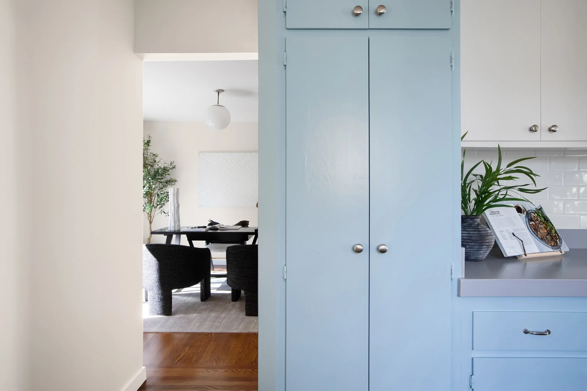 Tall kitchen pantry cabinet at 465 30th Street, with a view through to an adjoining room with hardwood floors