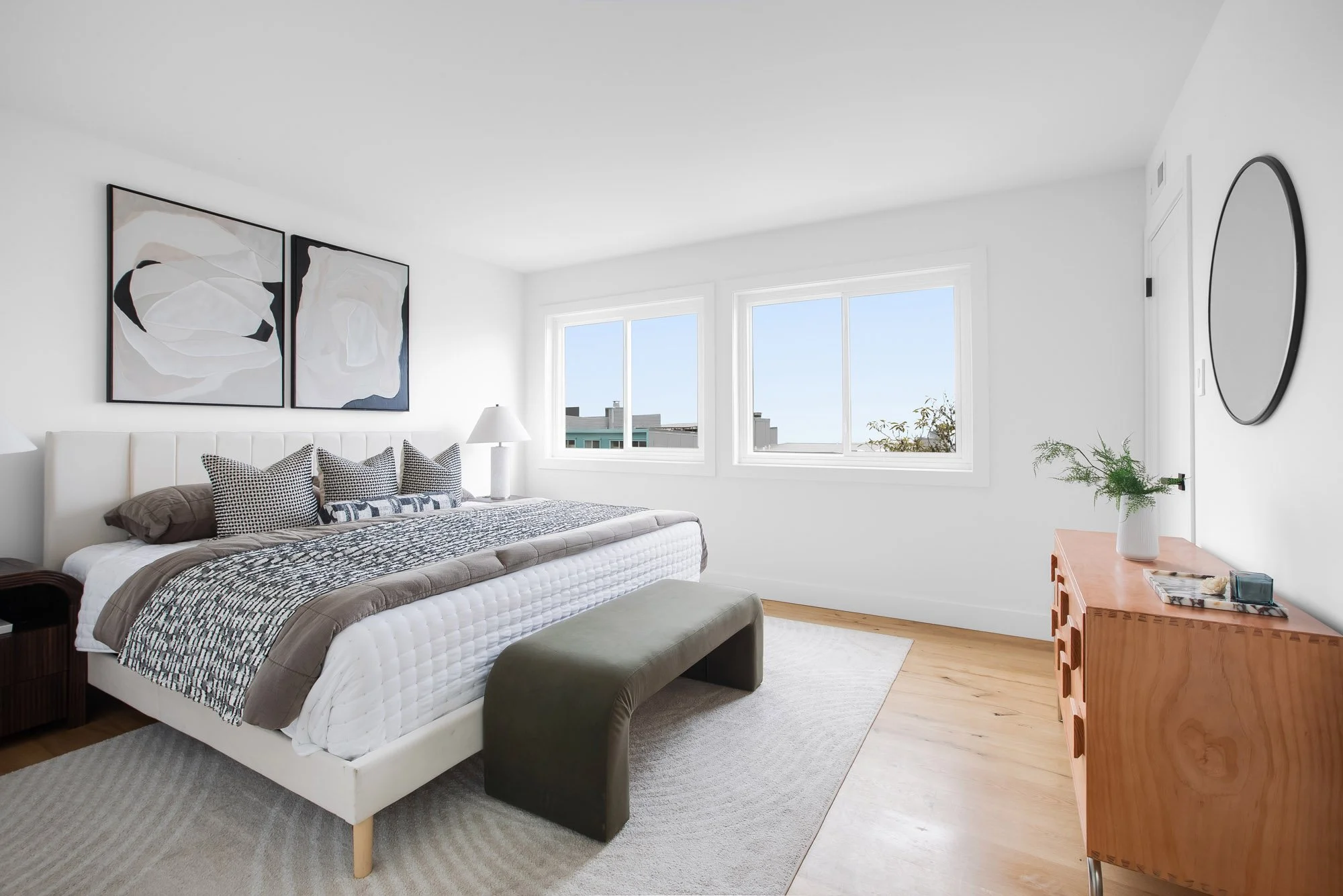 Primary bedroom at 75 Aloha Avenue in Golden Gate Heights, San Francisco, with paired windows over neighboring rooftops and refinished oak floors.