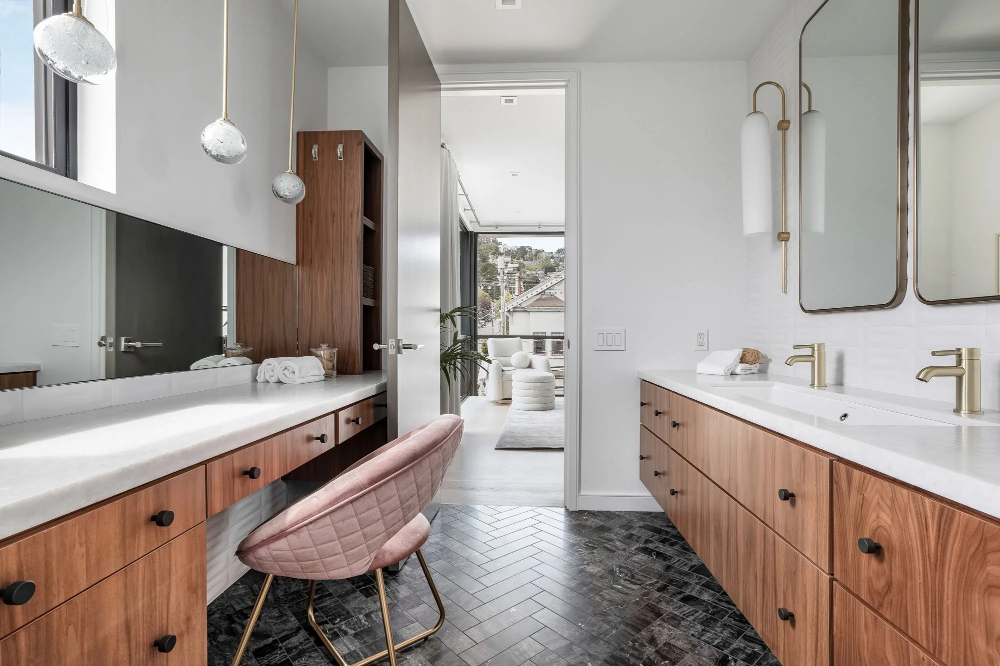 Luxury jack-and-jill bathroom vanity at 1647 Sanchez featuring custom walnut cabinetry, brushed gold fixtures, and a designer pink velvet vanity chair.
