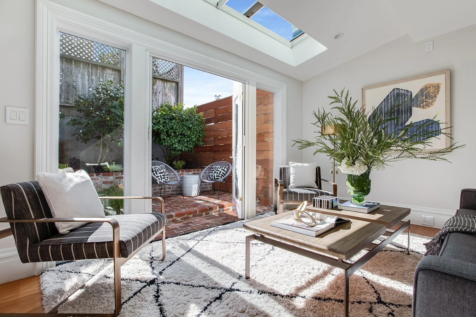 Contemporary family room with a massive overhead skylight and sliding glass doors that open to a private brick patio.