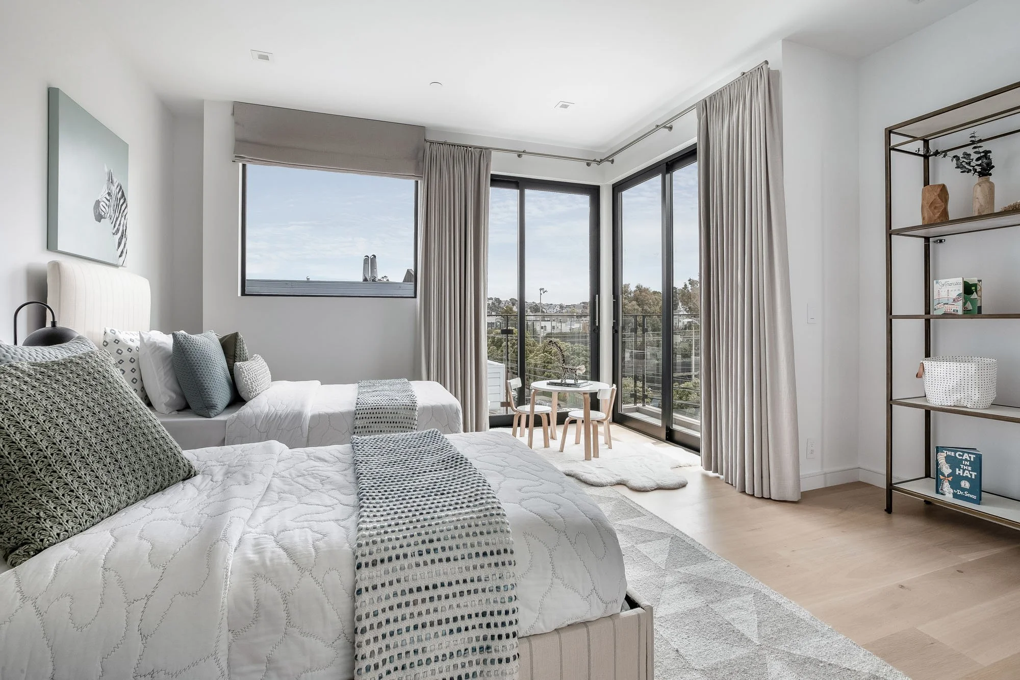Bright children’s bedroom at 1647 Sanchez with twin designer beds and floor-to-ceiling sliding glass doors opening to a private balcony with Noe Valley views.