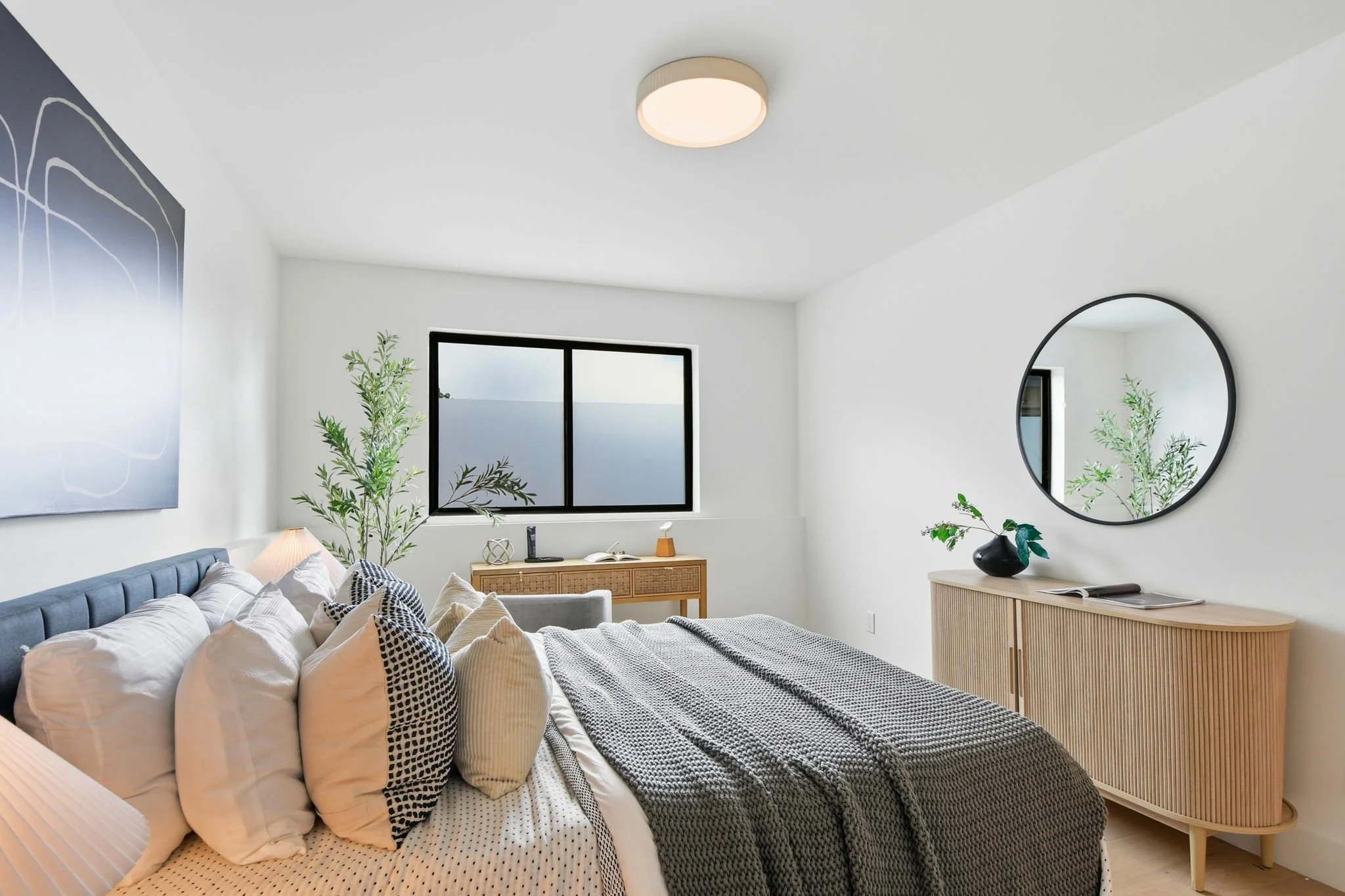 Side view of a staged bedroom in San Francisco highlighting premium textiles and contemporary furniture.