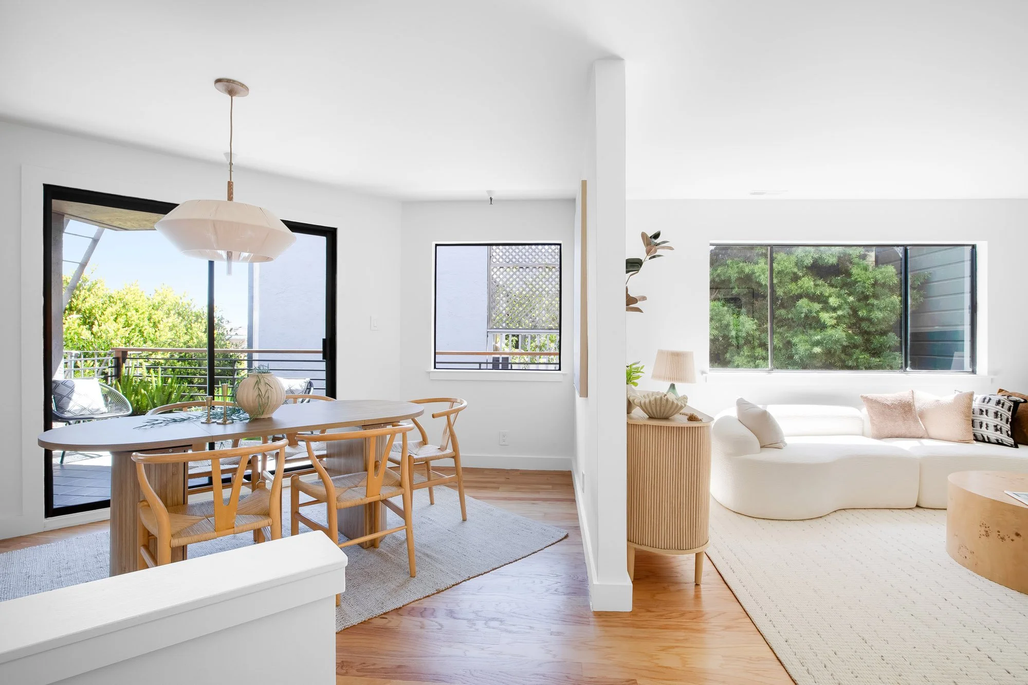 Dining and living space at 932 Broderick Street #2 with treetop views, a tiled fireplace, wet bar, and an open view into the primary bedroom.