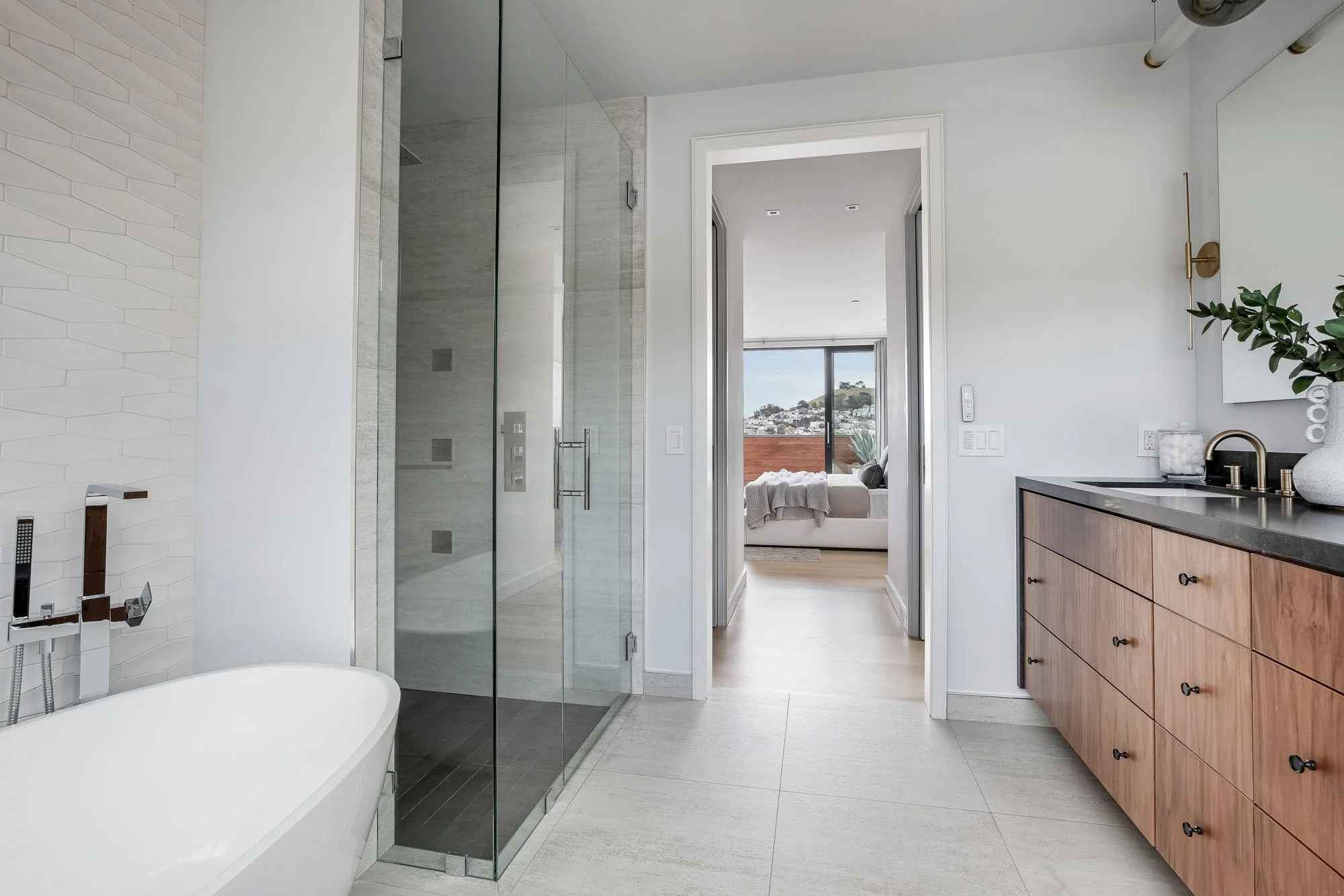 Spa-inspired primary bathroom at 1647 Sanchez with a frameless glass shower, soaking tub, and light-filled transition to the primary bedroom.