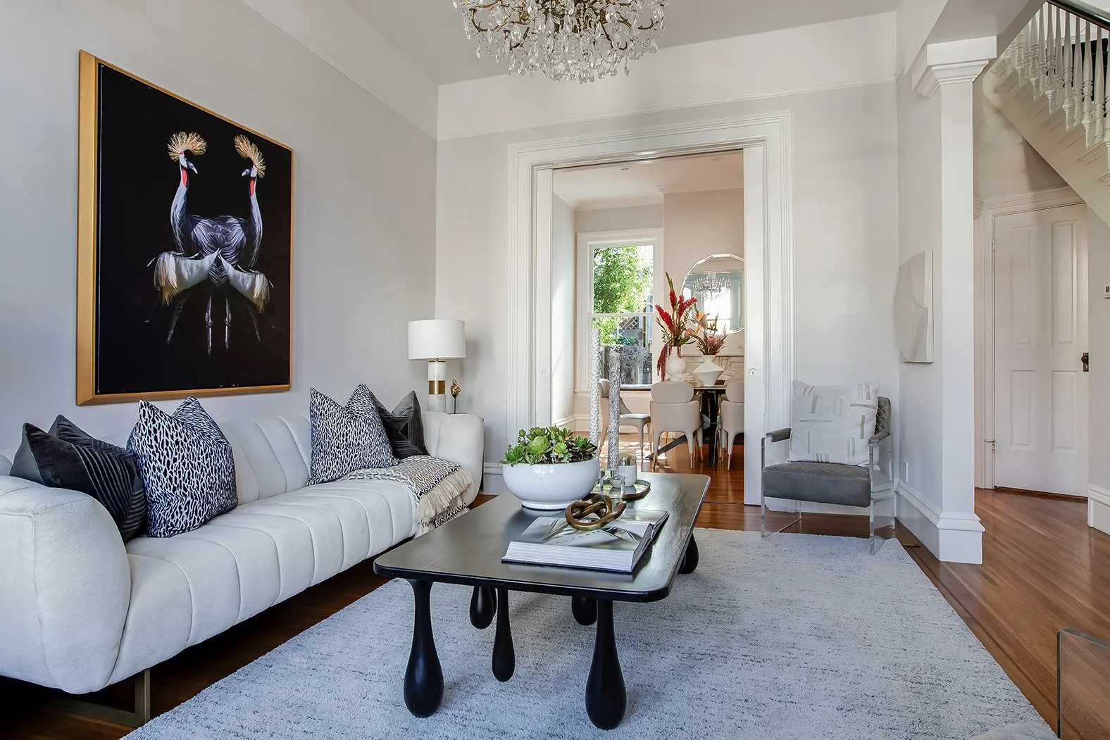 Designer living room looking through to the formal dining area, showcasing the expansive layout and natural light of a renovated Victorian.