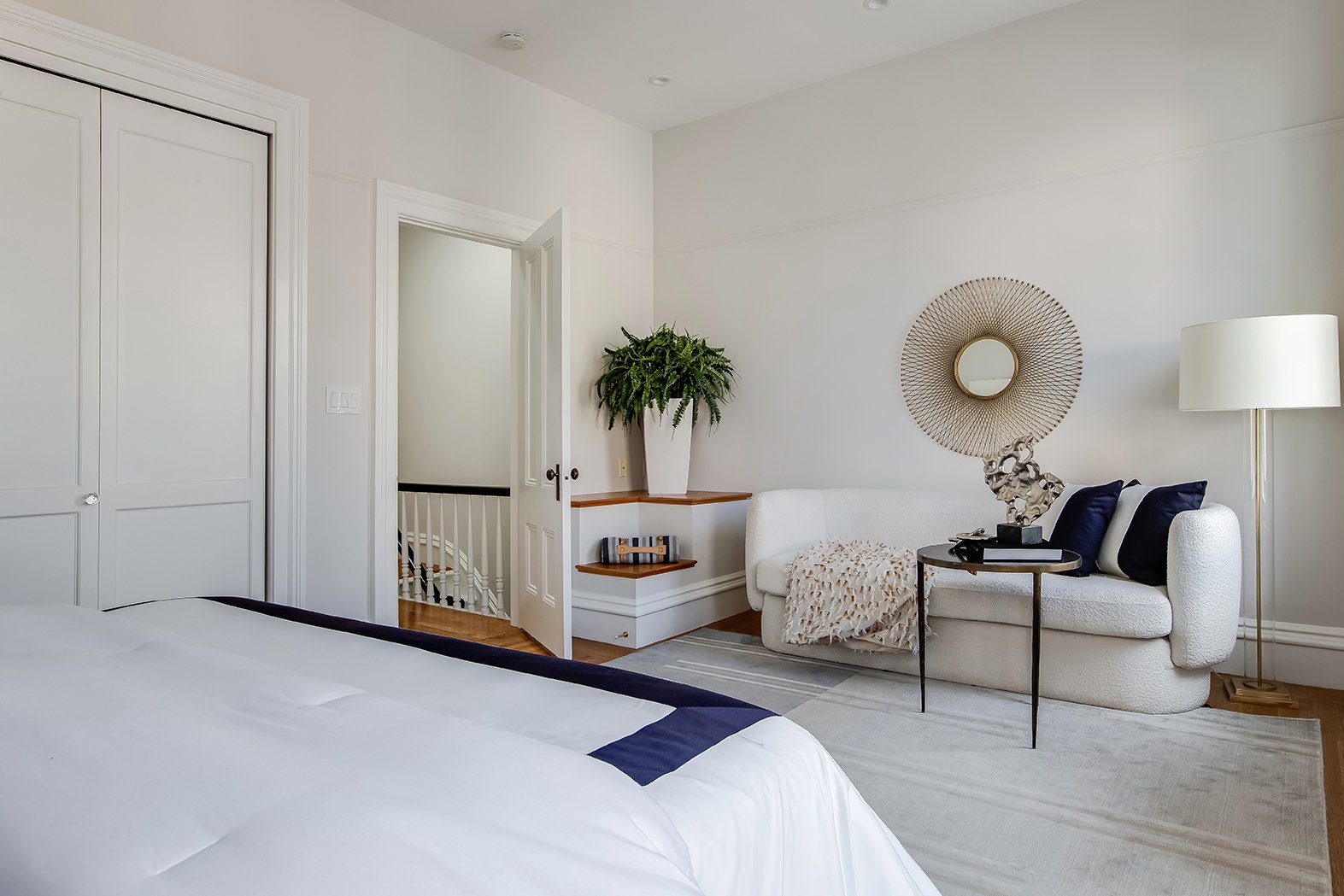 High-angle view of a luxury bedroom suite showing custom closets and a seamless transition to the home's grand staircase.