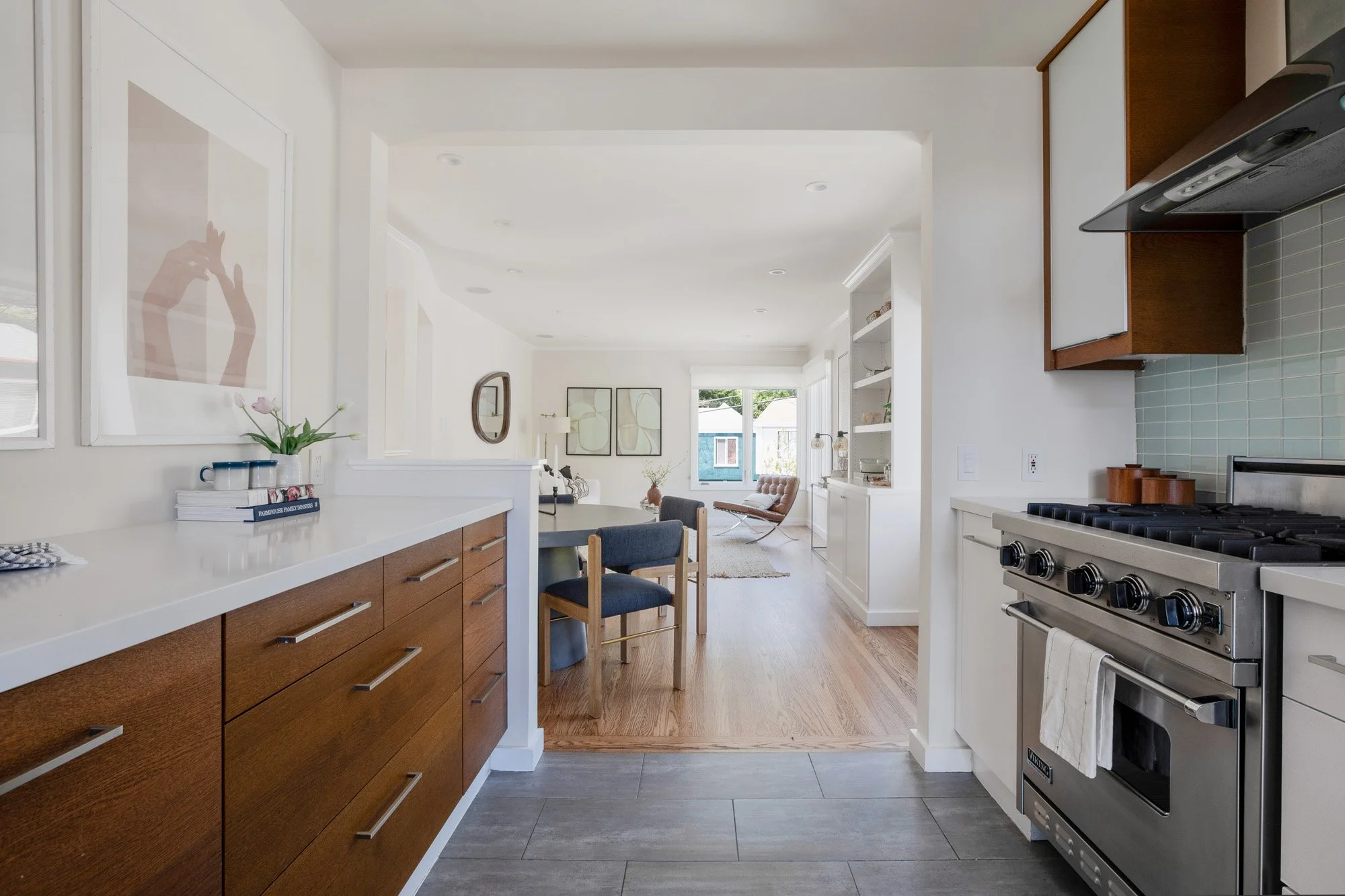 Elegant interior entryway featuring a natural wood staircase, slate tile flooring, and a black cane-front storage cabinet.