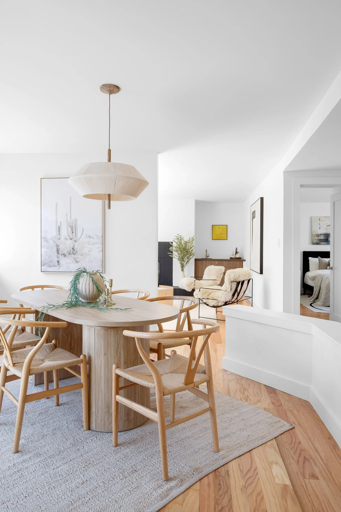 Light-filled dining room at 932 Broderick Street #2 with a wishbone-chair table set, leading into the living room and built-in wet bar.
