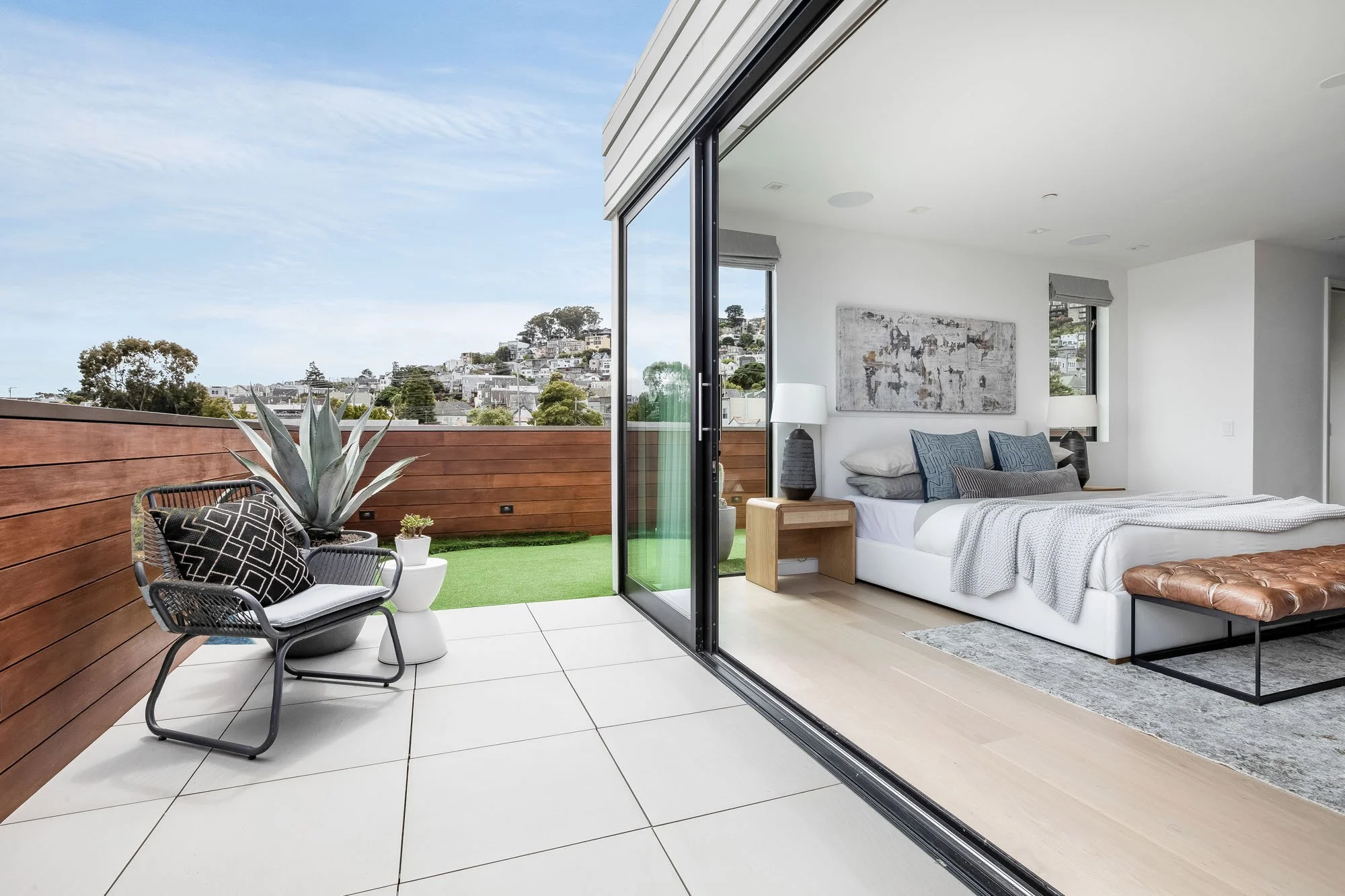 Private rooftop deck at 1647 Sanchez with modern lounge seating, agave planters, and panoramic views of the San Francisco skyline and Noe Valley.