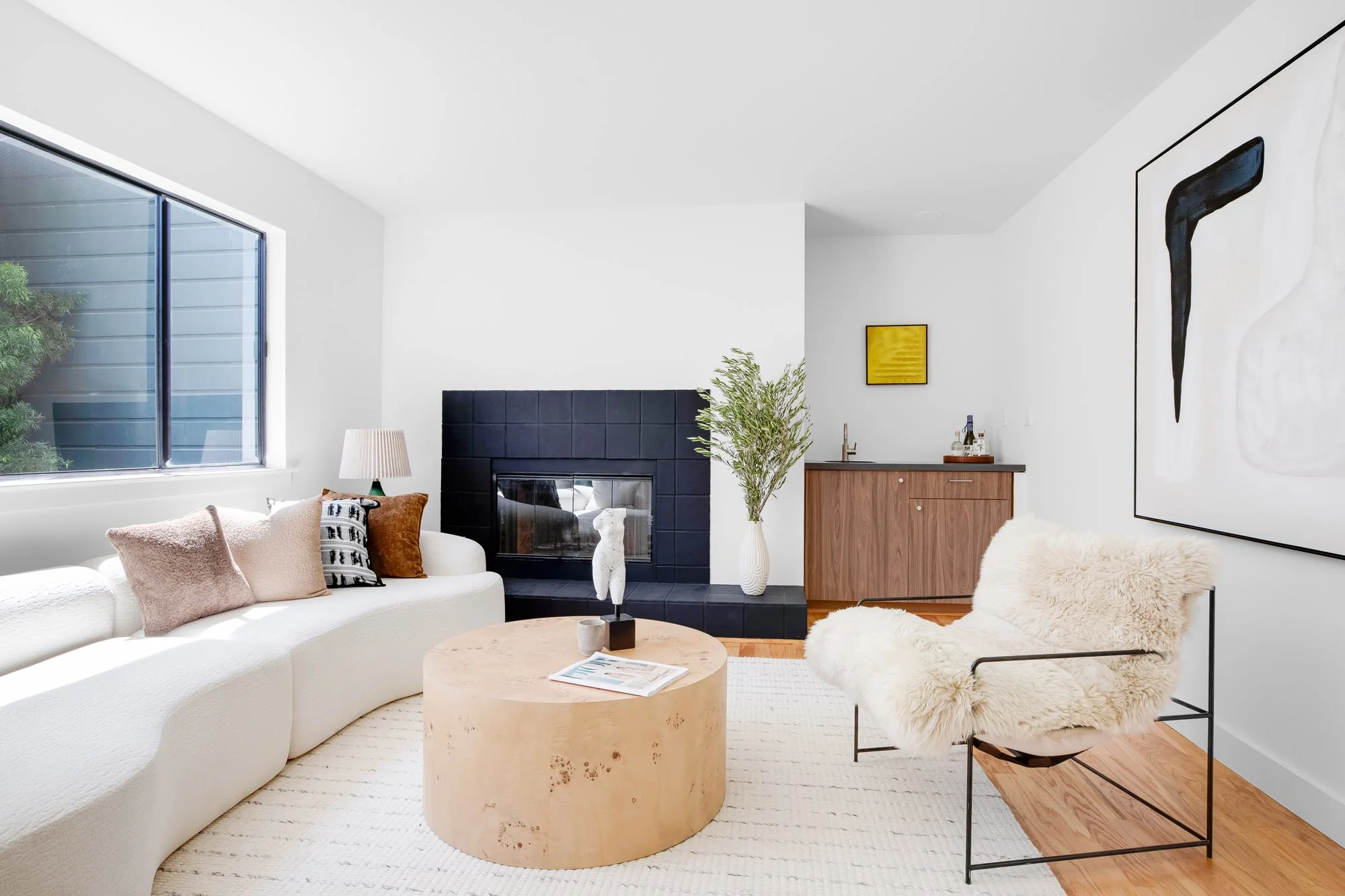 Living room at 932 Broderick Street #2 with a black-tiled gas fireplace, built-in walnut wet bar, and open-concept flow to the dining area.