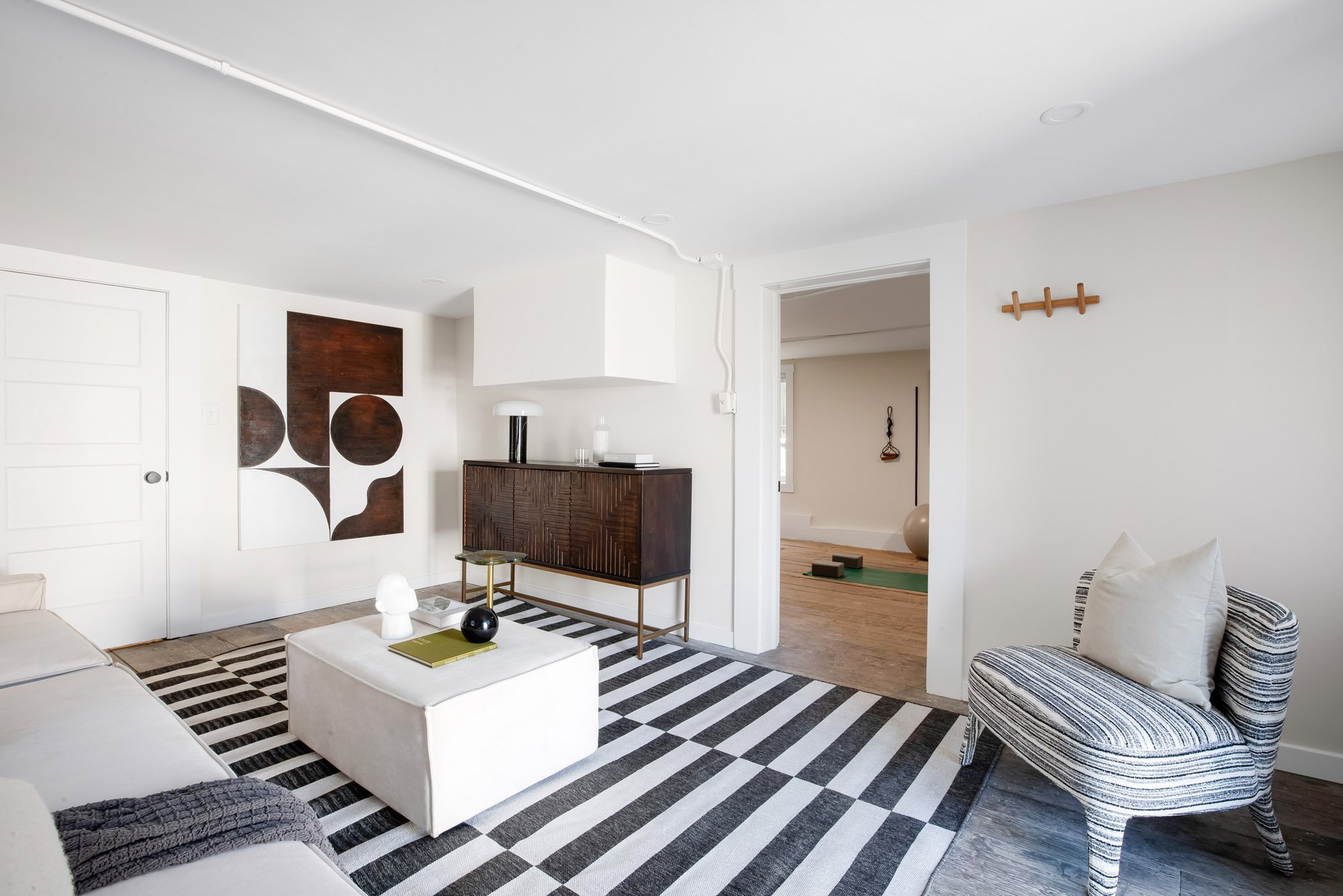 Finished lower-level room at 465 30th Street in Upper Noe Valley with wide-plank wood floors, recessed lighting and a doorway to a second finished room
