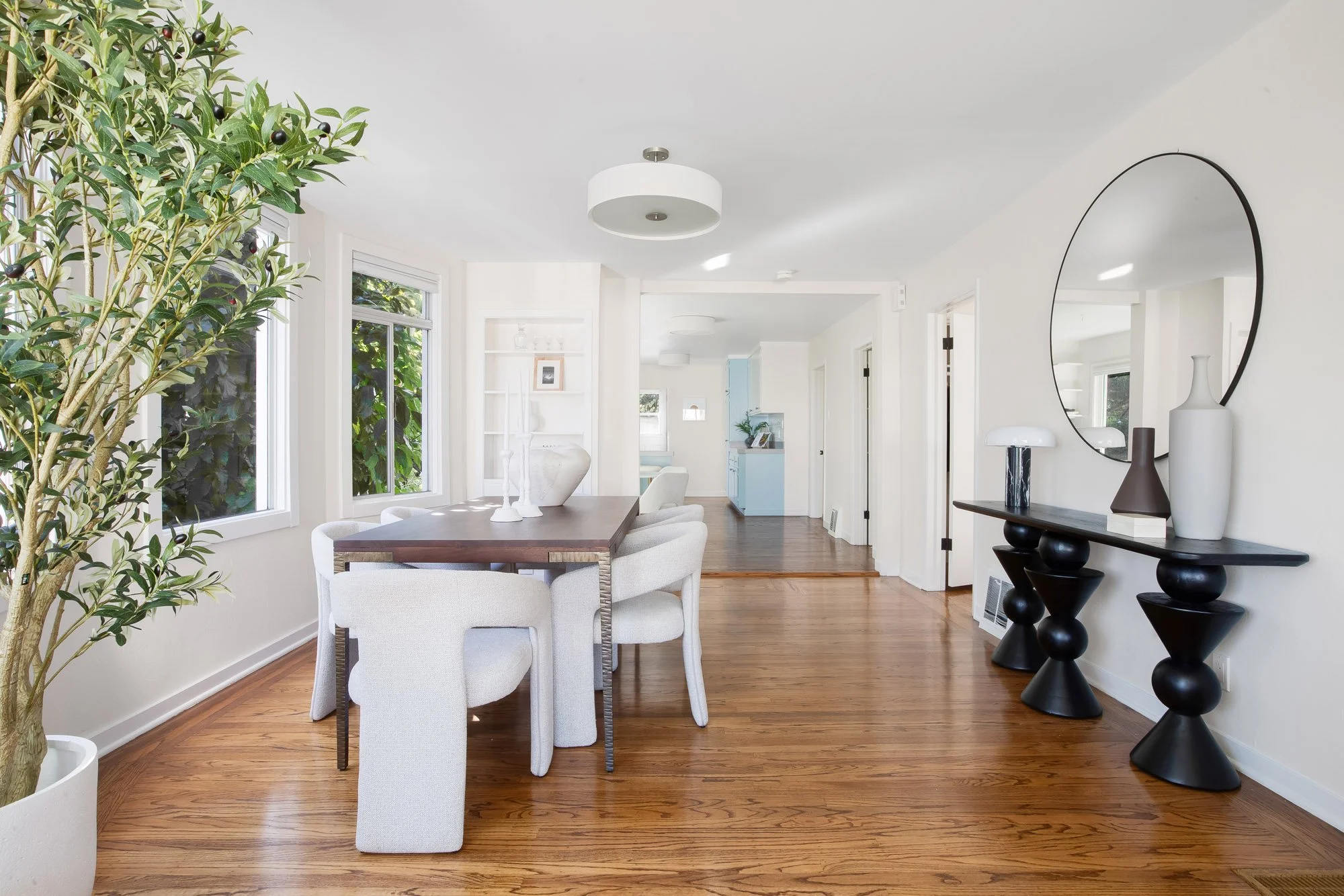 Dining area at 465 30th Street with hardwood floors, garden-facing windows and built-in shelving, opening to the hallway and eat-in kitchen
