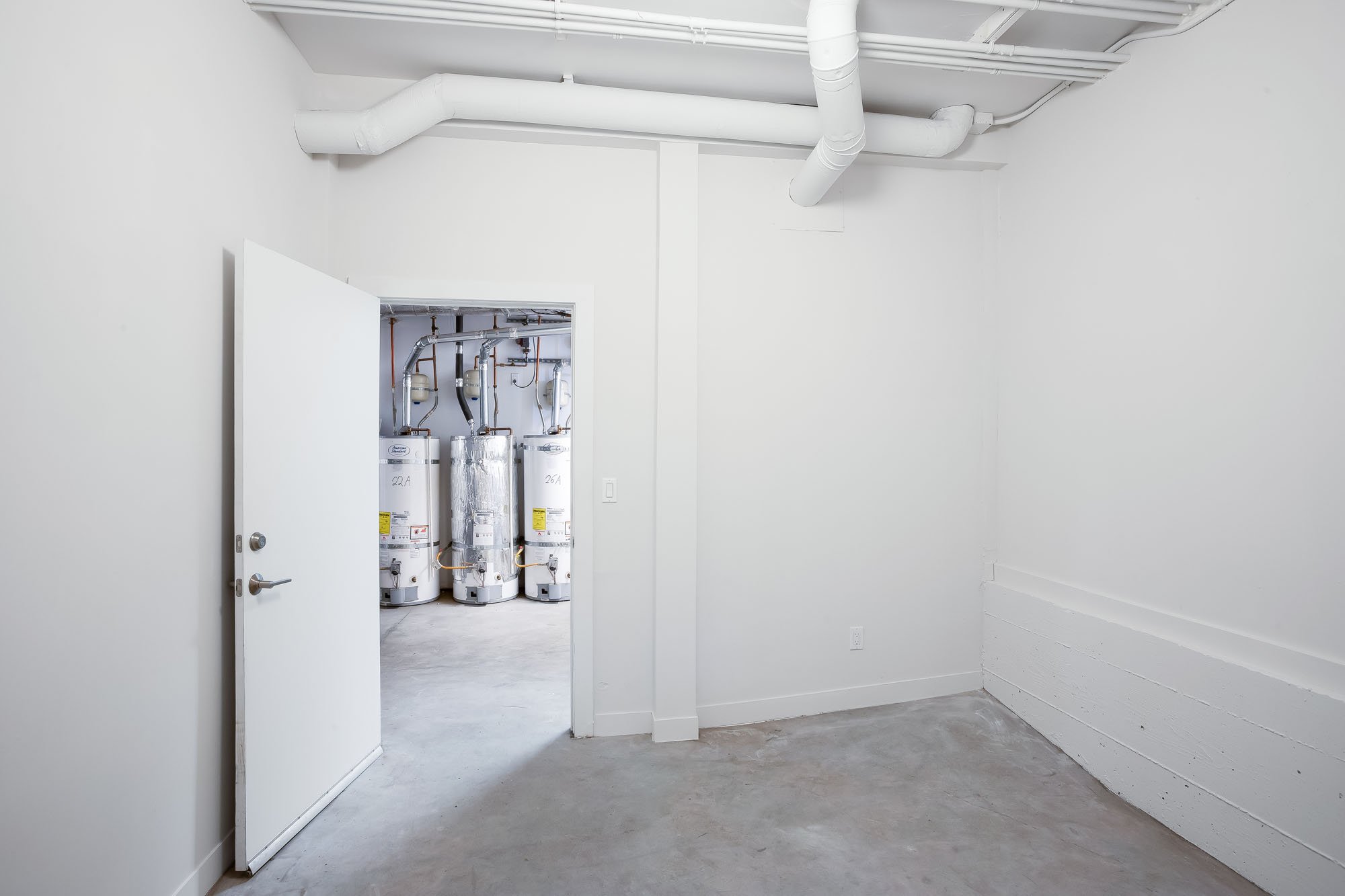 Resident storage area at 3426 19th St in San Francisco with a view into the building's modern utility and water heater room.