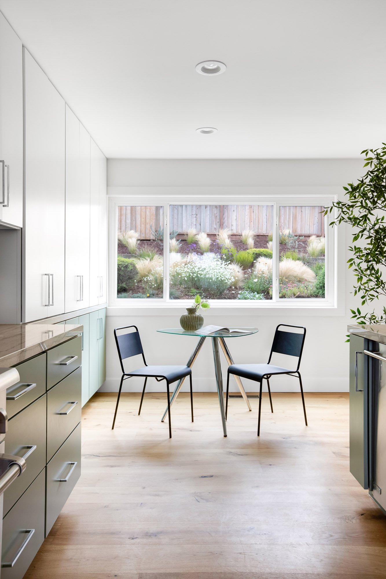 Kitchen eating area at 75 Aloha Avenue in Golden Gate Heights, San Francisco, with sage-green cabinetry and a window over the drought-tolerant planted hillside.