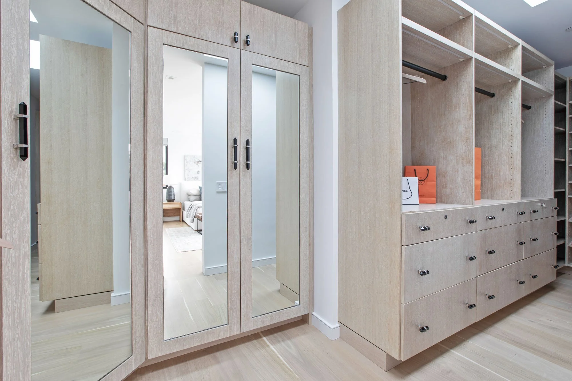 Designer walk-in closet with custom light wood millwork, floor-to-ceiling mirrors, and high-end organizational storage at 1647 Sanchez.