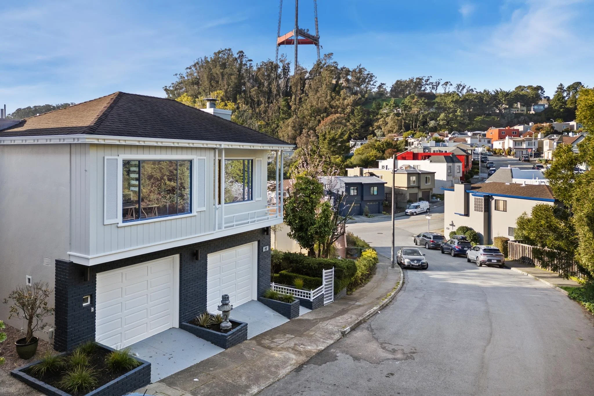 Street-level aerial view of a mid-century modern home at 147 Gladeview Way, San Francisco, with Sutro Tower visible on the horizon.