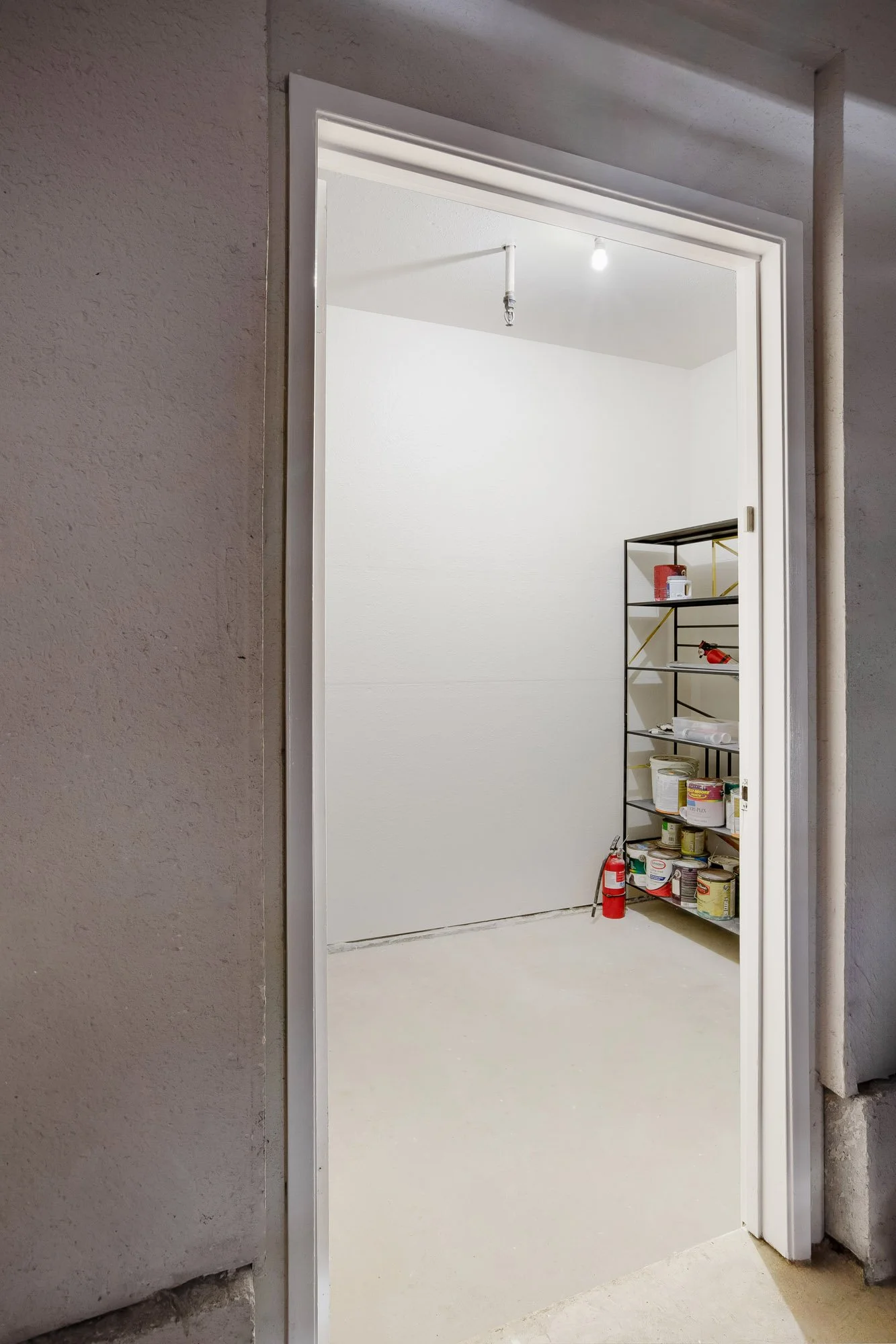 Private storage room at 932 Broderick Street #2 with finished floors and shelving, offering extra storage space for the condo.