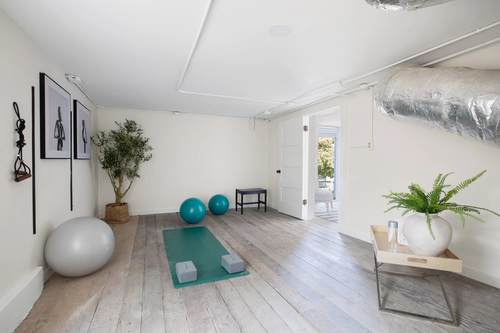Second finished lower-level room at 465 30th Street with wide-plank wood floors and its own door to the street-level entry