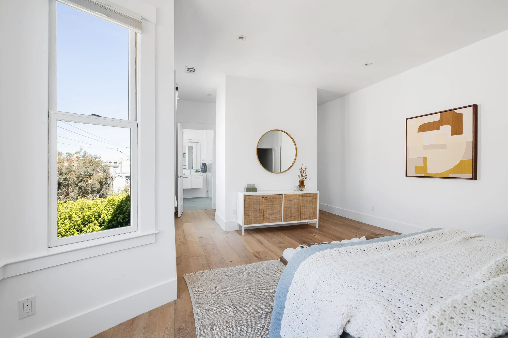 Spacious primary bedroom layout in a Mission Dolores condo with minimalist decor and views of the surrounding neighborhood.