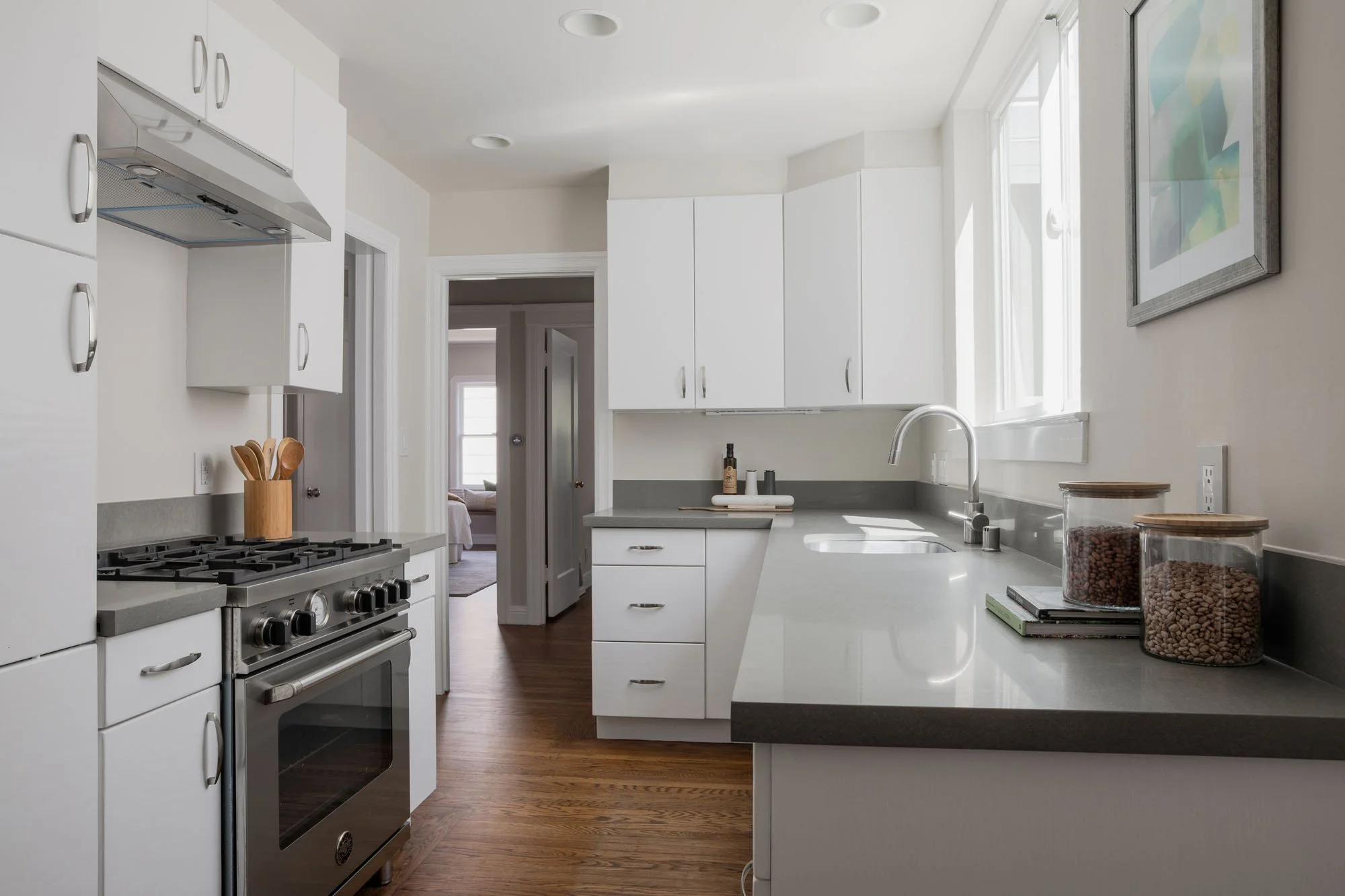 Chef’s kitchen featuring a premium gas range, minimalist white cabinets, and polished quartz counters in a renovated San Francisco home.