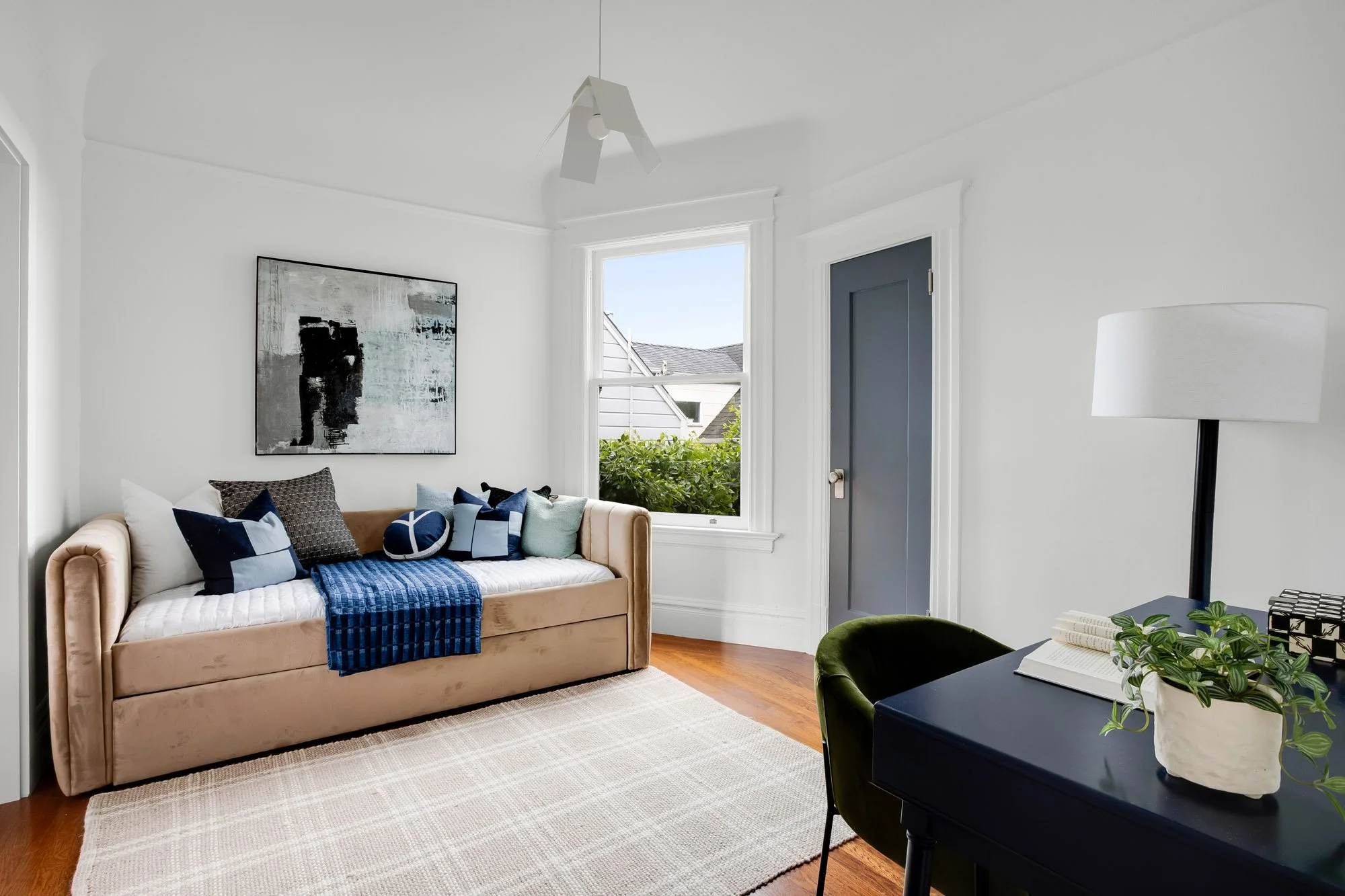 Flexible third bedroom used as home office and guest room with original hardwood floors, crown molding, south-facing window, and garden views in luxury Presidio Heights Victorian condo, San Francisco