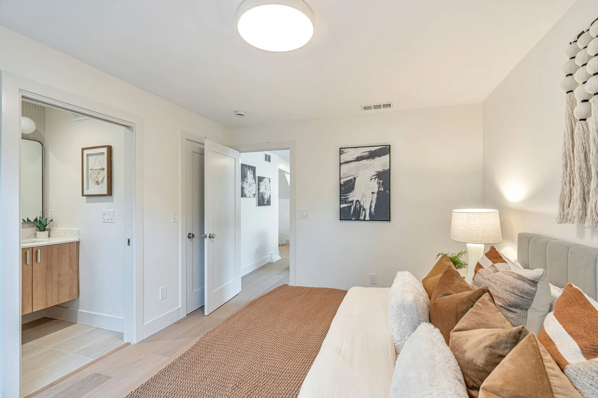 Spacious bedroom layout showing the architectural flow between the sleeping area, a modern ensuite bathroom, and the walk-in closet in a renovated family home.