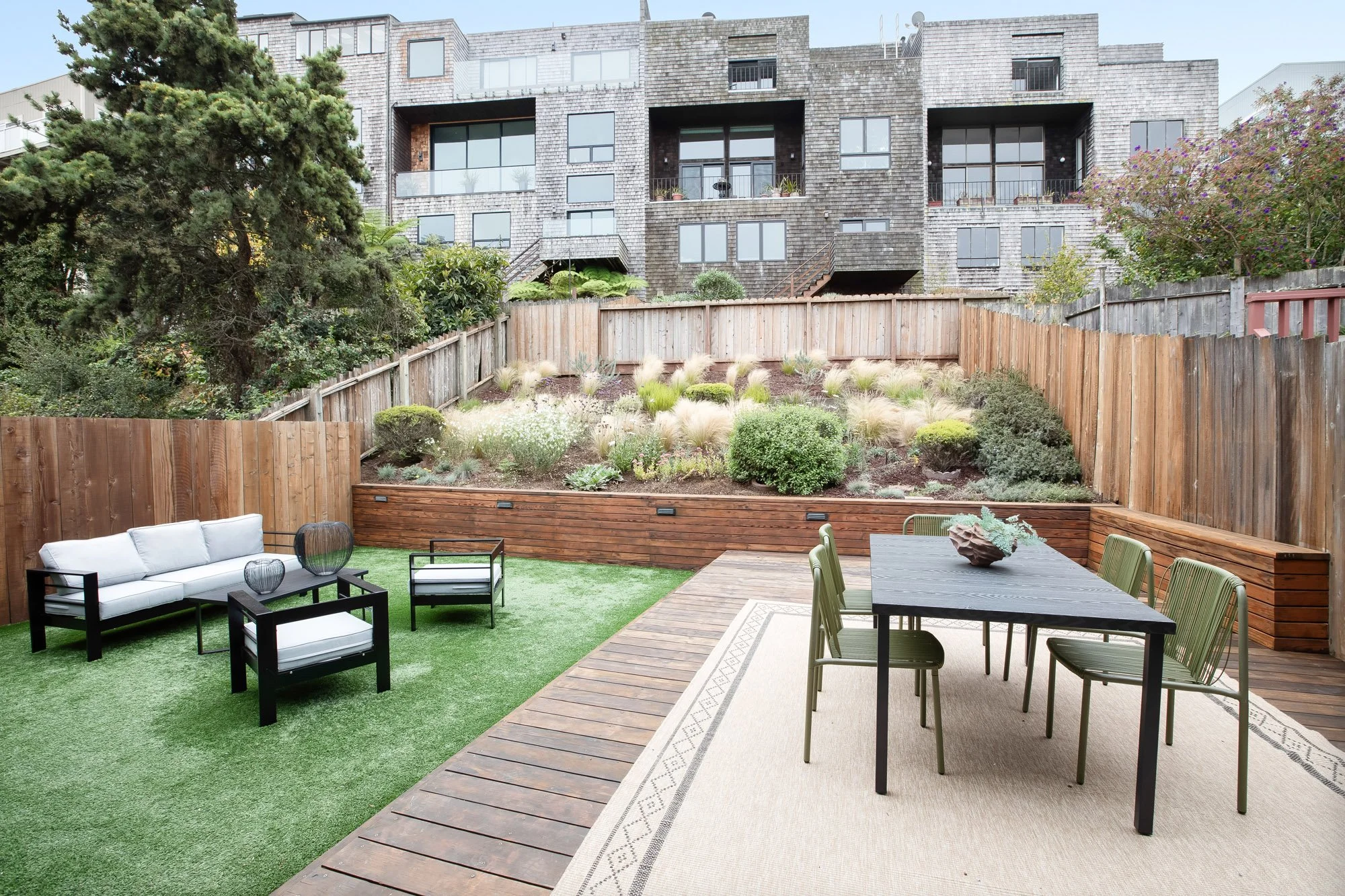 Rear yard at 75 Aloha Avenue in Golden Gate Heights, San Francisco, with a refinished deck, turfed lawn, and a hillside planted in drought-tolerant Mediterranean species.