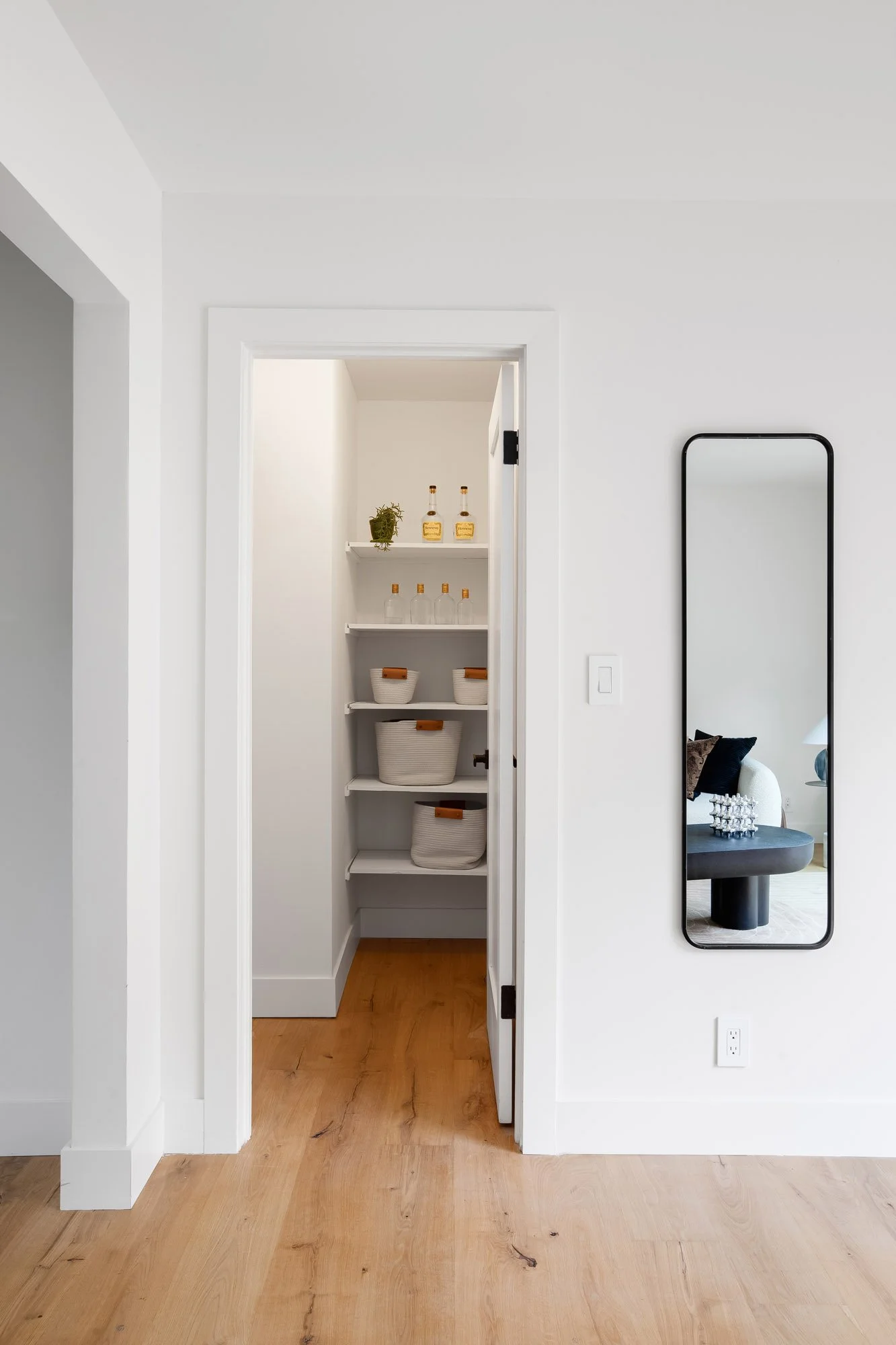 Large linen closet at 75 Aloha Avenue, San Francisco, with fixed shelving, opening off an oak-floored upstairs hall.