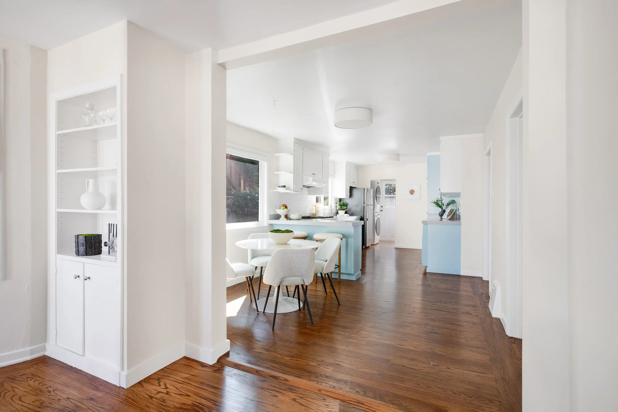 Recently updated eat-in kitchen at 465 30th Street with new hardwood floors, a breakfast peninsula with counter seating, stainless appliances, and laundry by the rear door
