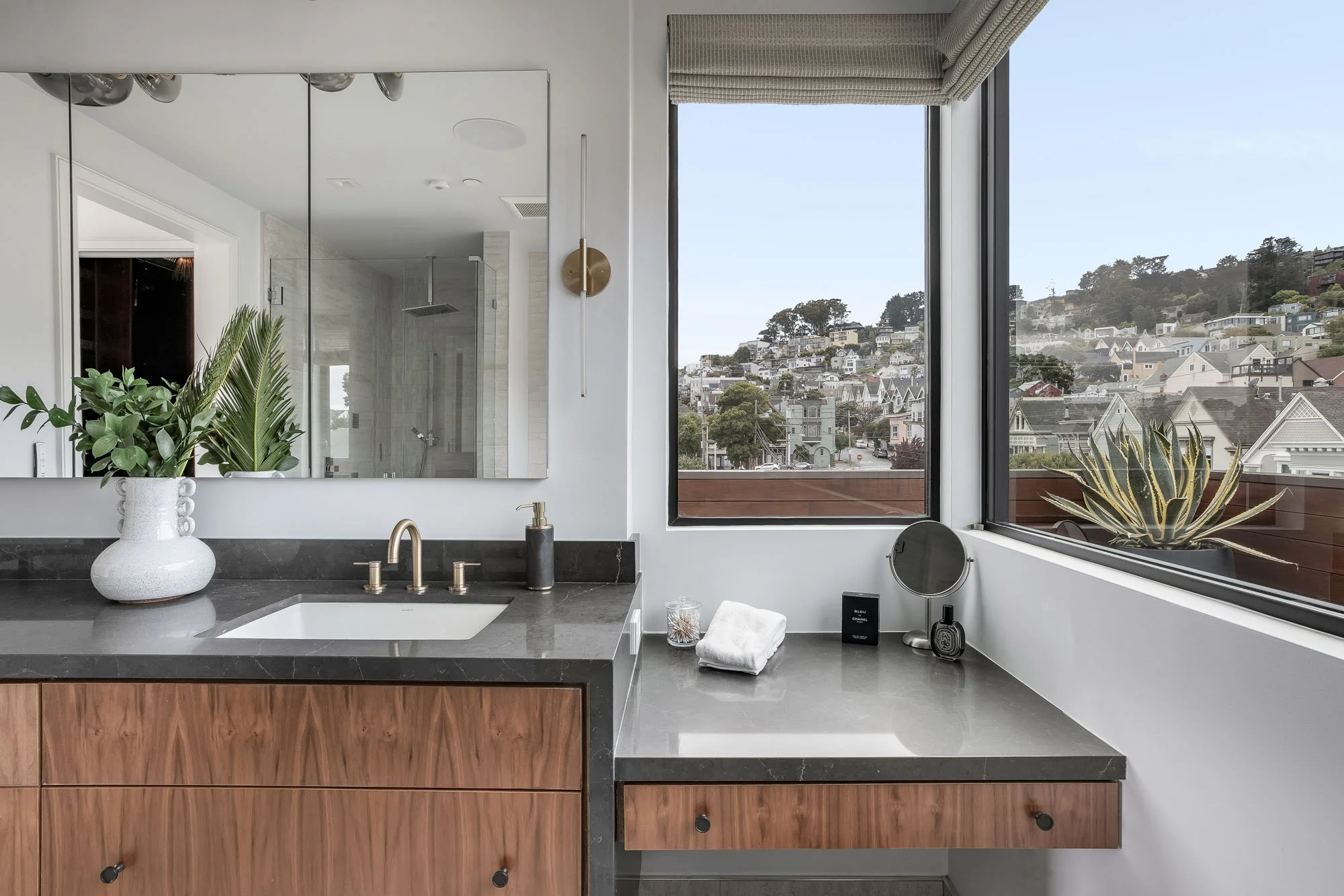 Detail of luxury primary ensuite bathroom with custom walnut bathroom cabinetry and dark stone countertops at 1647 Sanchez, overlooking iconic San Francisco Victorian homes in Noe Valley.