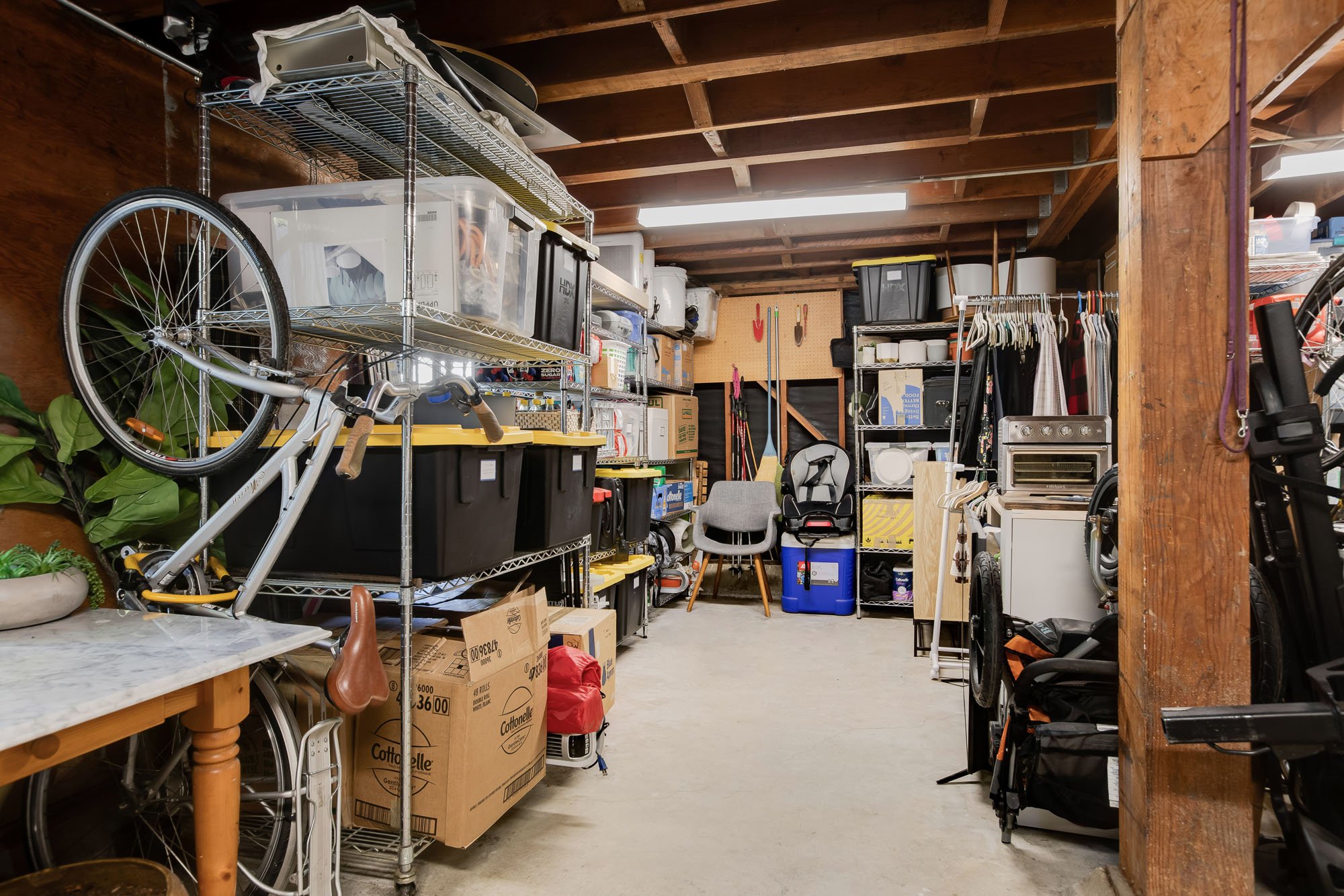 A large, organized garage and storage room at 144 Lower Terrace, featuring high ceilings, wire shelving units, and ample space for bikes and gear.
