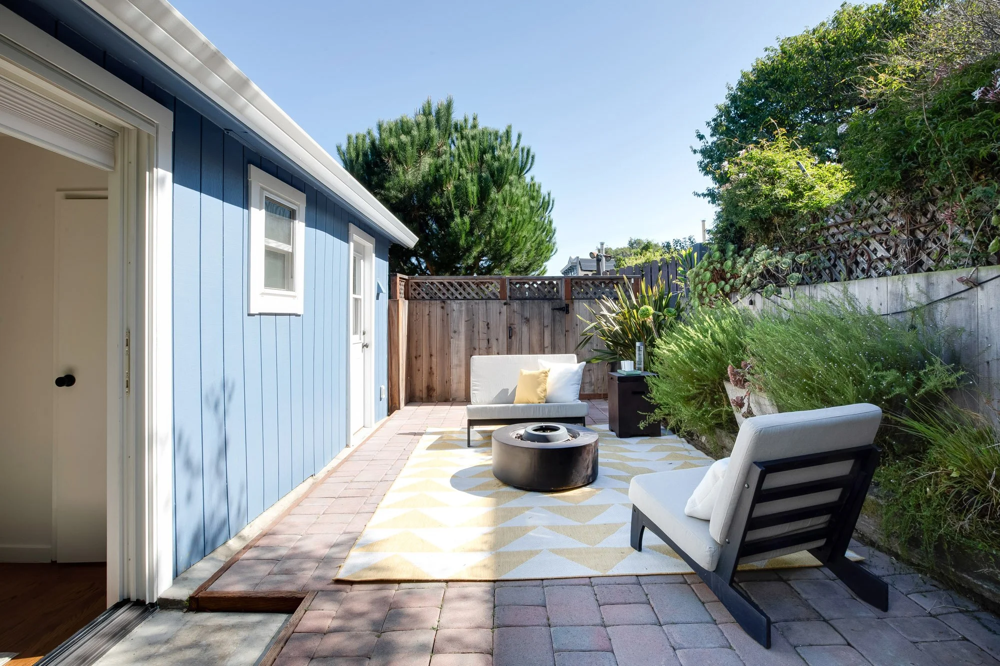Private pavered patio at 465 30th Street with a new wood fence and gate, framed by established, drought-tolerant landscaping