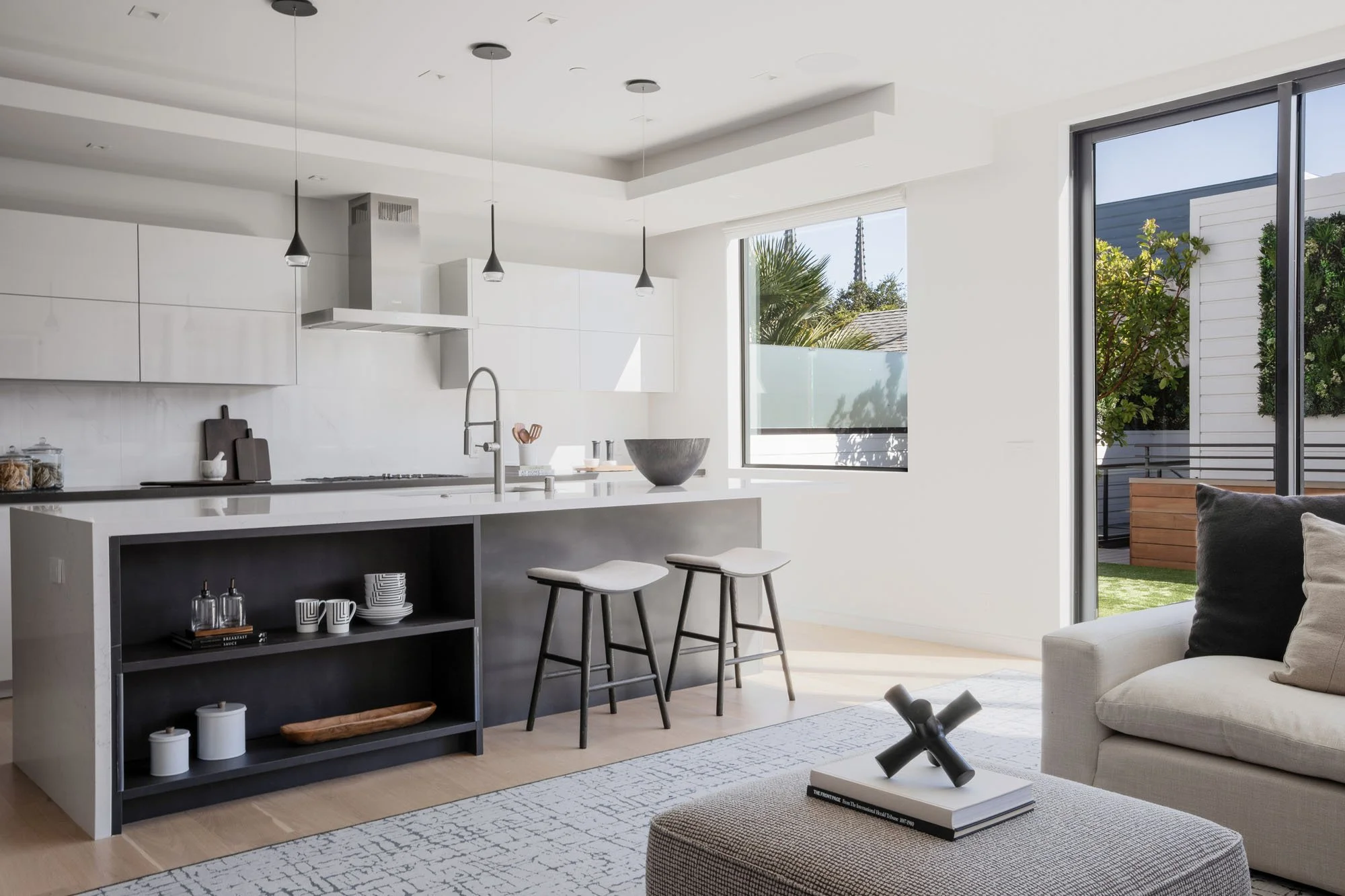 Modern kitchen at 1647 Sanchez featuring a white marble waterfall island, dark wood open shelving, and minimalist black pendant lighting in a luxury San Francisco home.