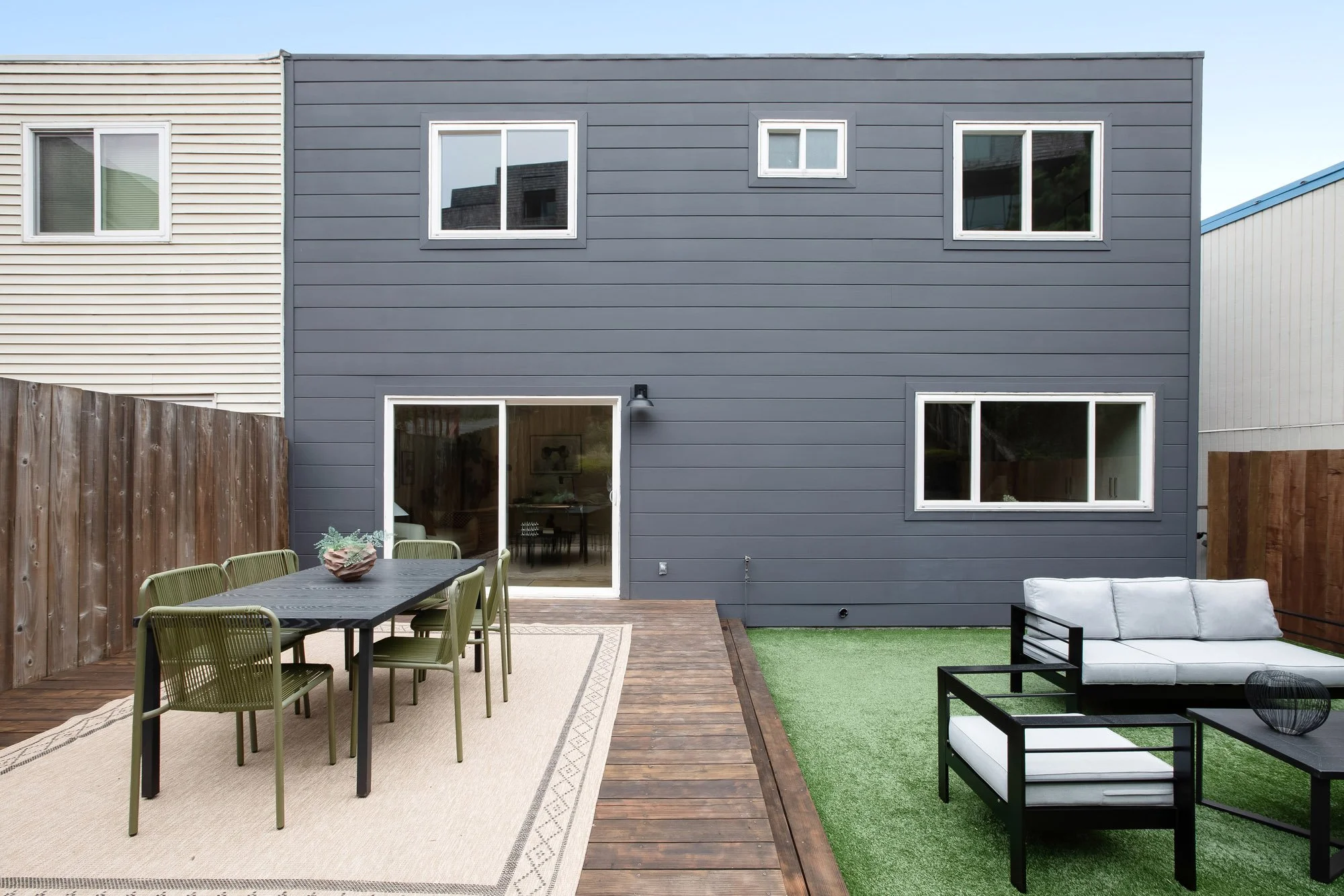 Rear elevation of 75 Aloha Avenue, San Francisco, with the bonus room slider opening onto the refinished deck and turfed lawn.